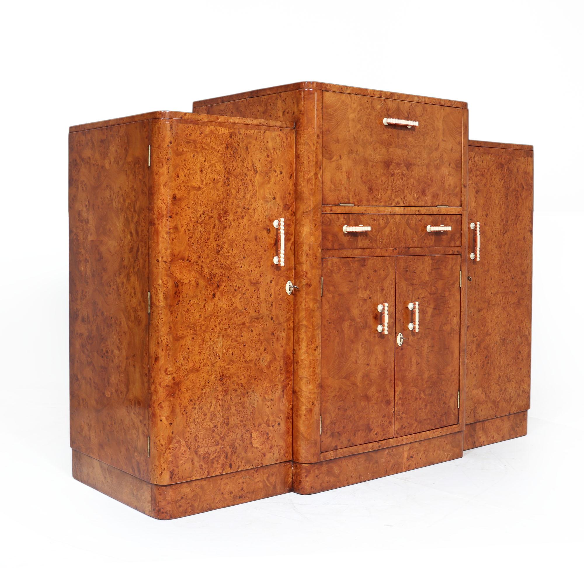 Art Deco cocktail sideboard
A lovely English Art Deco sideboard with central pop out cocktail, the sideboard has four doors, the outer two having adjustable shelves and central cupboard having drinks bottle holders above this is is a baize lined