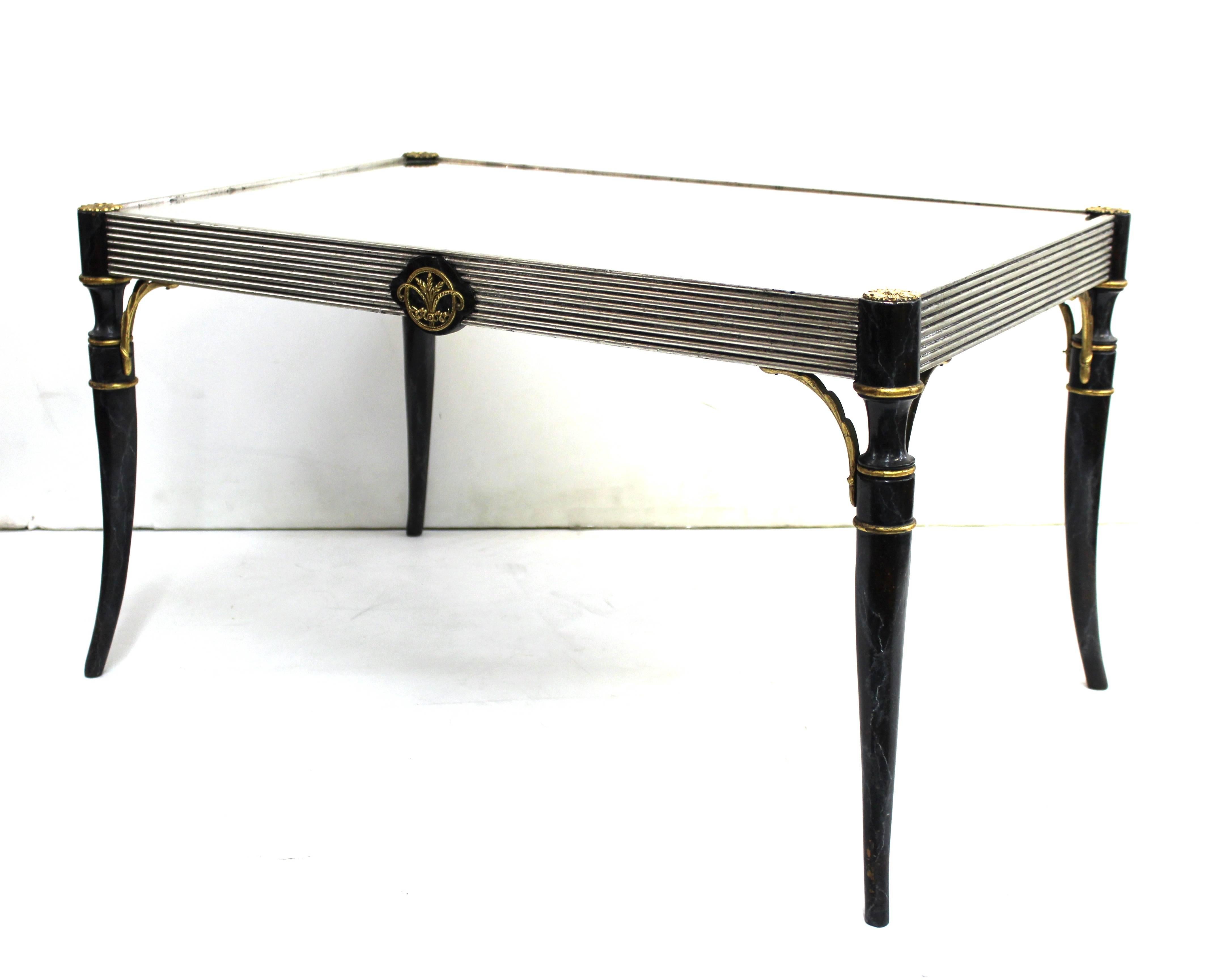 Art Deco period cocktail or coffee table in hand-painted and silvered wood with metal embellishments and a mirror top. The piece is reminiscent of the style of Maison Baguès, and was made in the 1940s. Some wear to the paint. In good vintage
