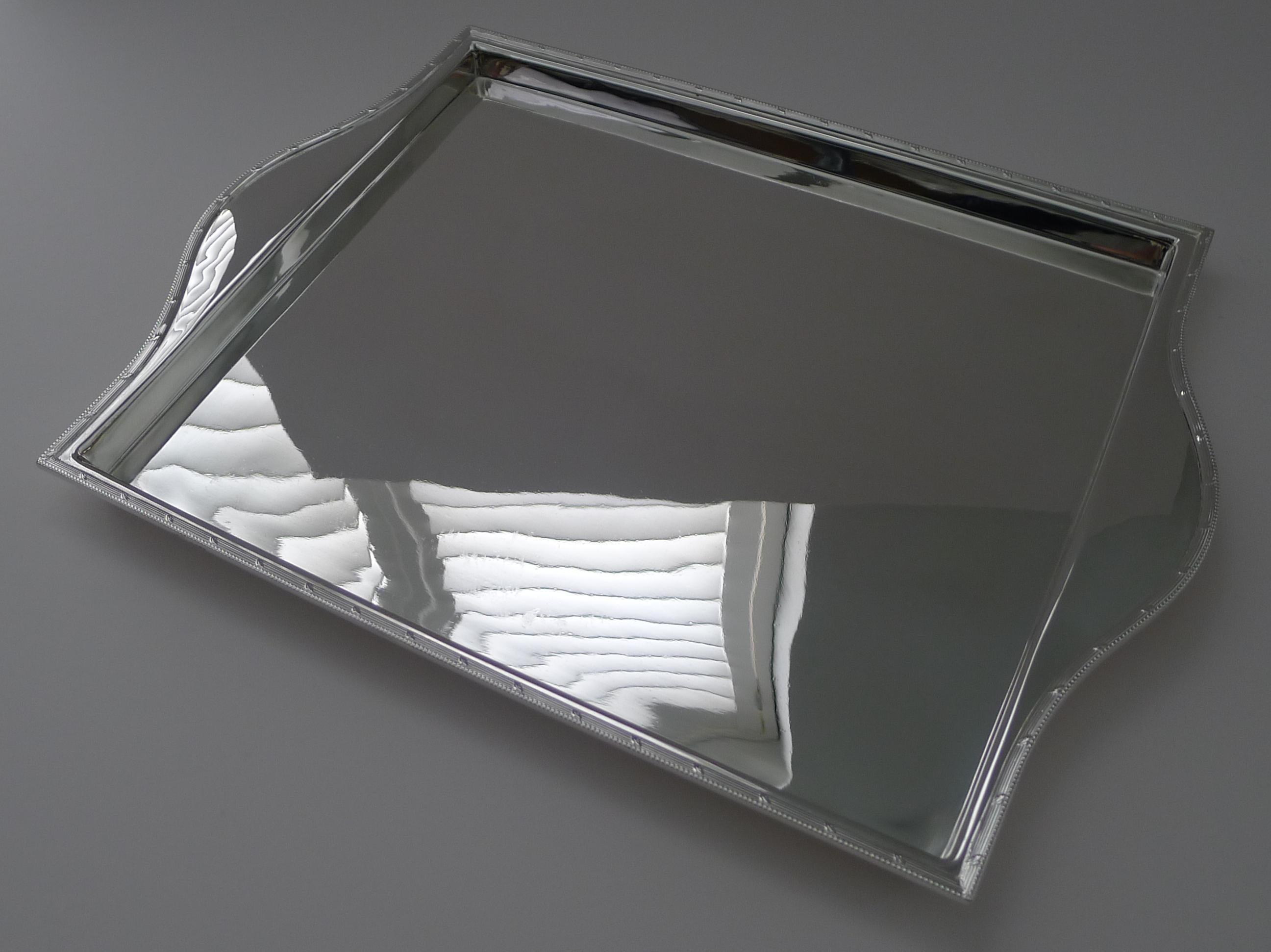A simple and highly stylish English cocktail tray made from silver plate with an integral handle to each side and an elegant raised border.

The tray has just been returned from our silversmith where it has been professionally cleaned and polished,