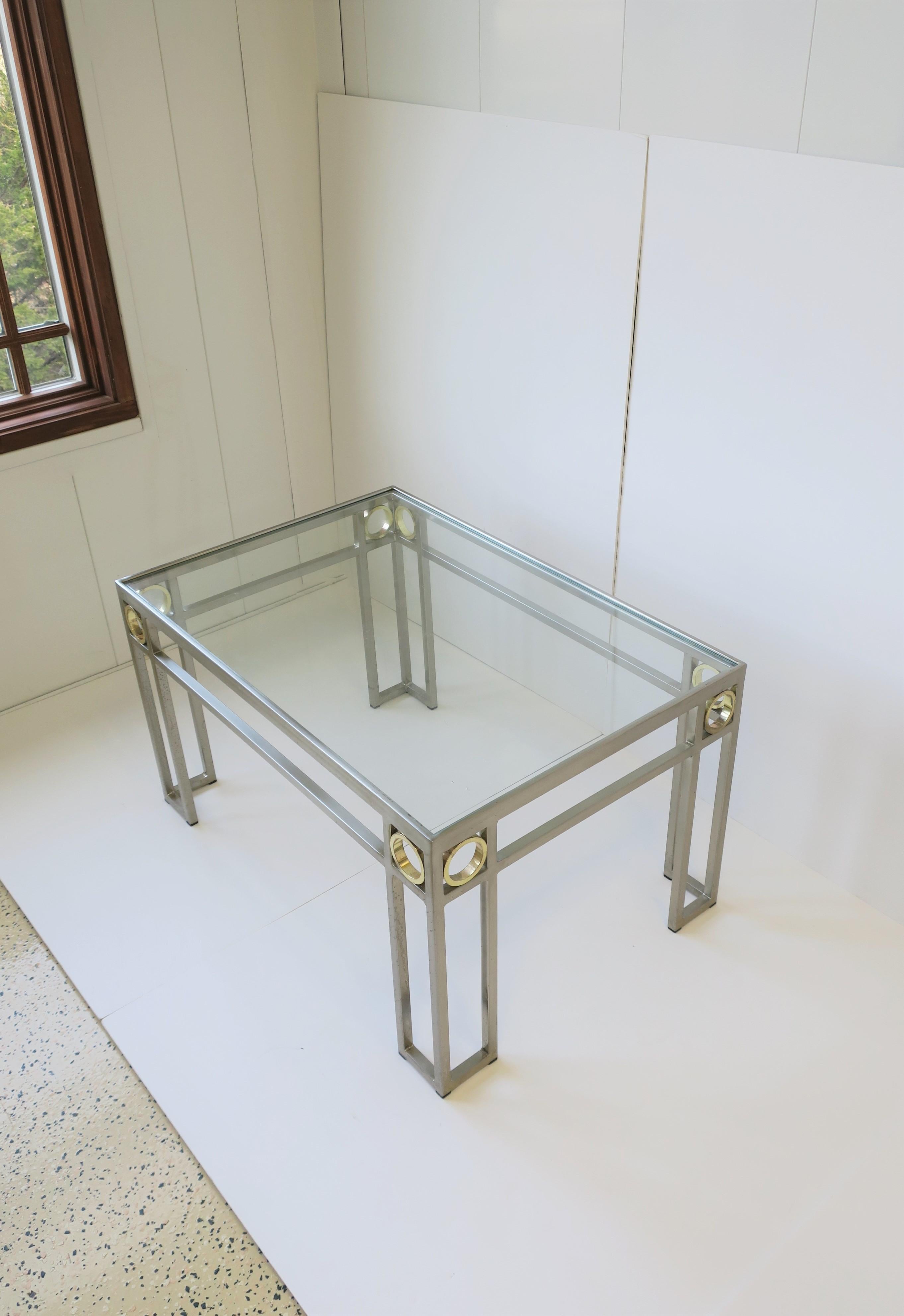 A beautiful and substantial Art Deco coffee or cocktail table. Table is rectangular with an inset glass top, steel frame, and gold colored geometric accents, circa 1990s.

Table measures: 31