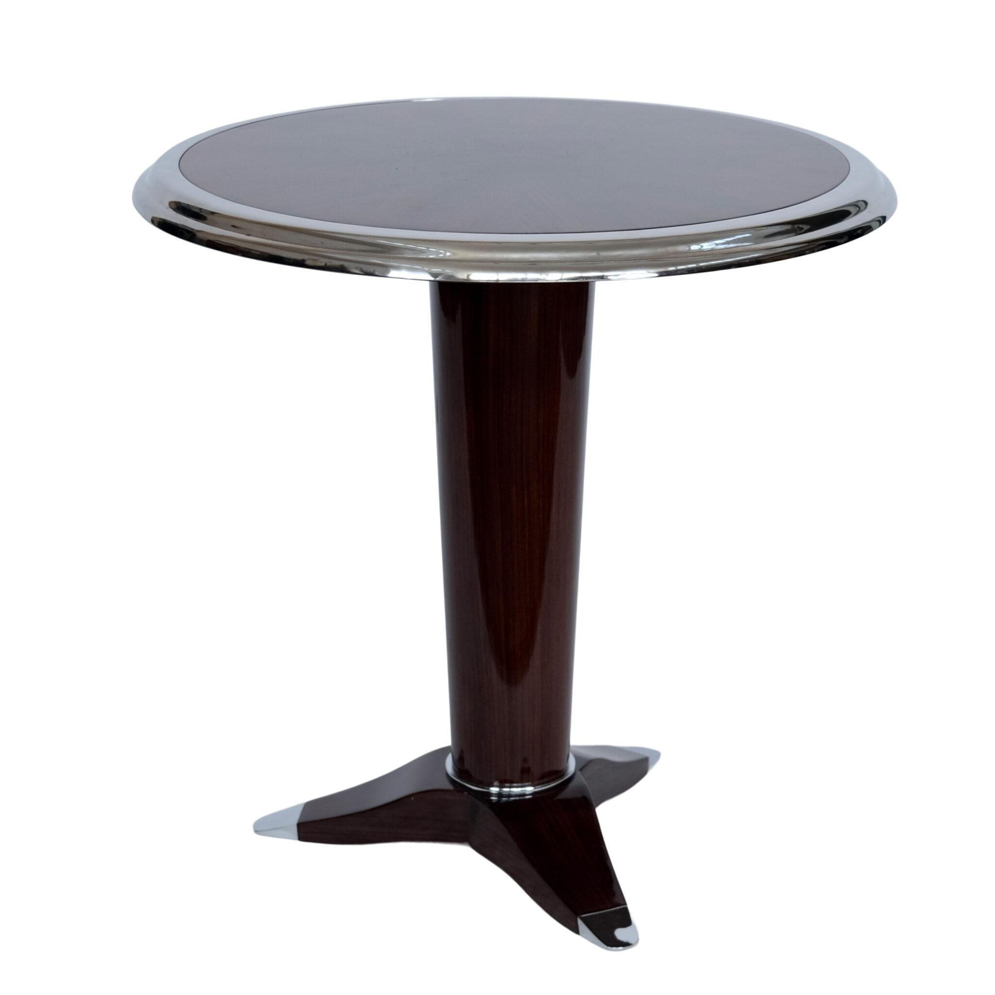 Table basse Art Déco
Table ronde Art Déco (Reproduction dans le style Art Déco)

Table d'appoint/bistrot élégante avec un plateau en placage foncé brillant et une lunette en métal chromé/nickel qui l'entoure. La colonne centrale effilée repose sur