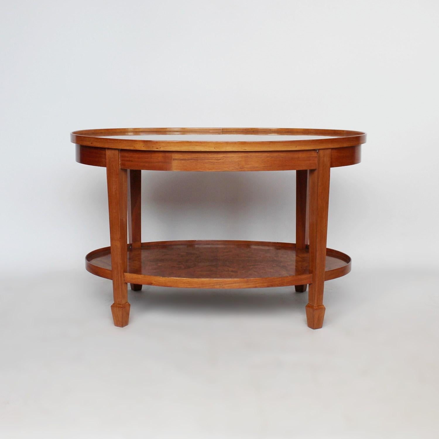 An Art Deco, oval coffee table with shelf. Burr walnut top with straight grain walnut frame and solid walnut legs.



