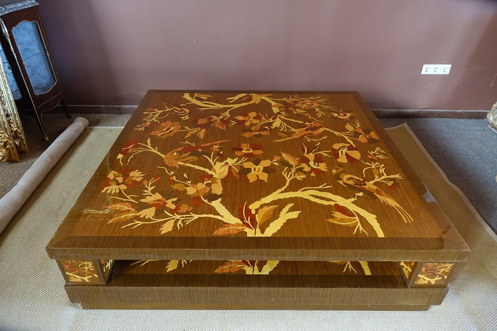 An impressive Art Deco square coffee table. The dark palisander exterior with inlaid hand-carved marquetry in richly textured rosewood, walnut and maple. The marquetry runs across both the table surface and the middle surface. The French polishing