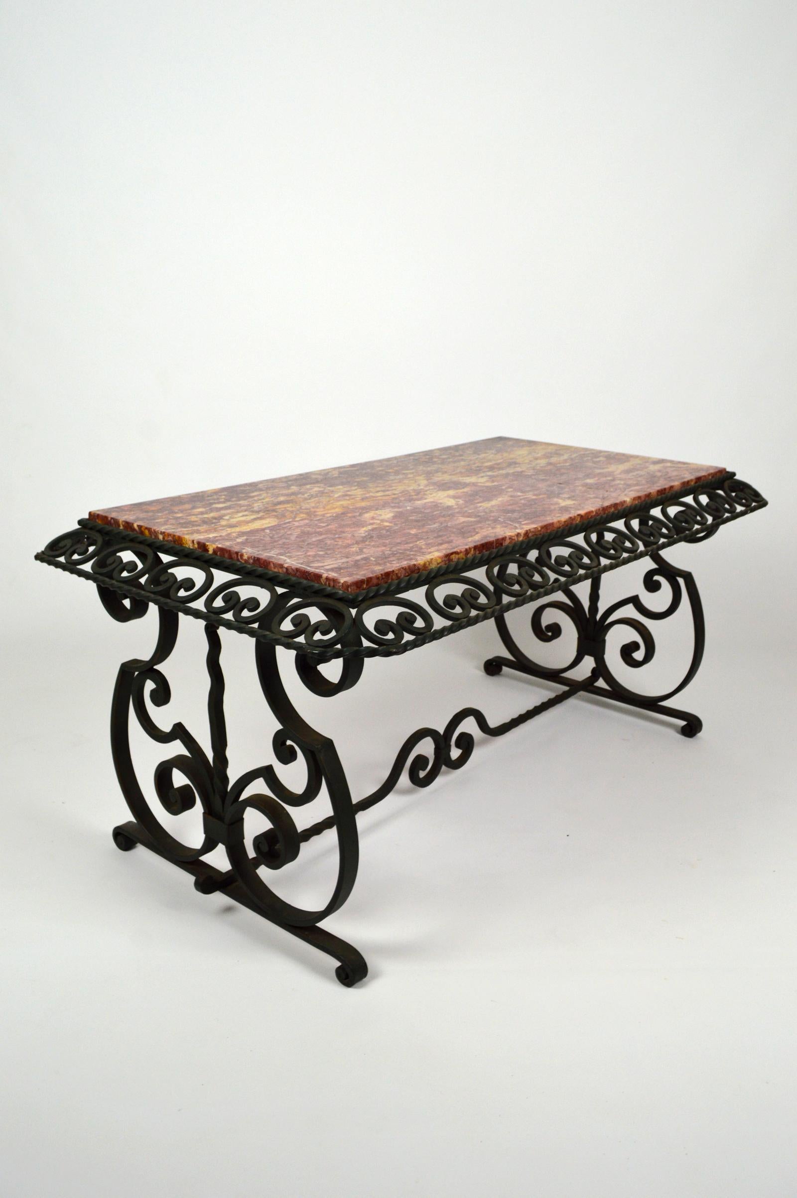 Elegant wrought iron coffee / side table with pink marble top.
The wrought iron structure is painted dark green.
Beautiful ironwork.

Art Deco, France, circa 1940.
Unsigned. In the style of the productions, at the same period, of Gilbert