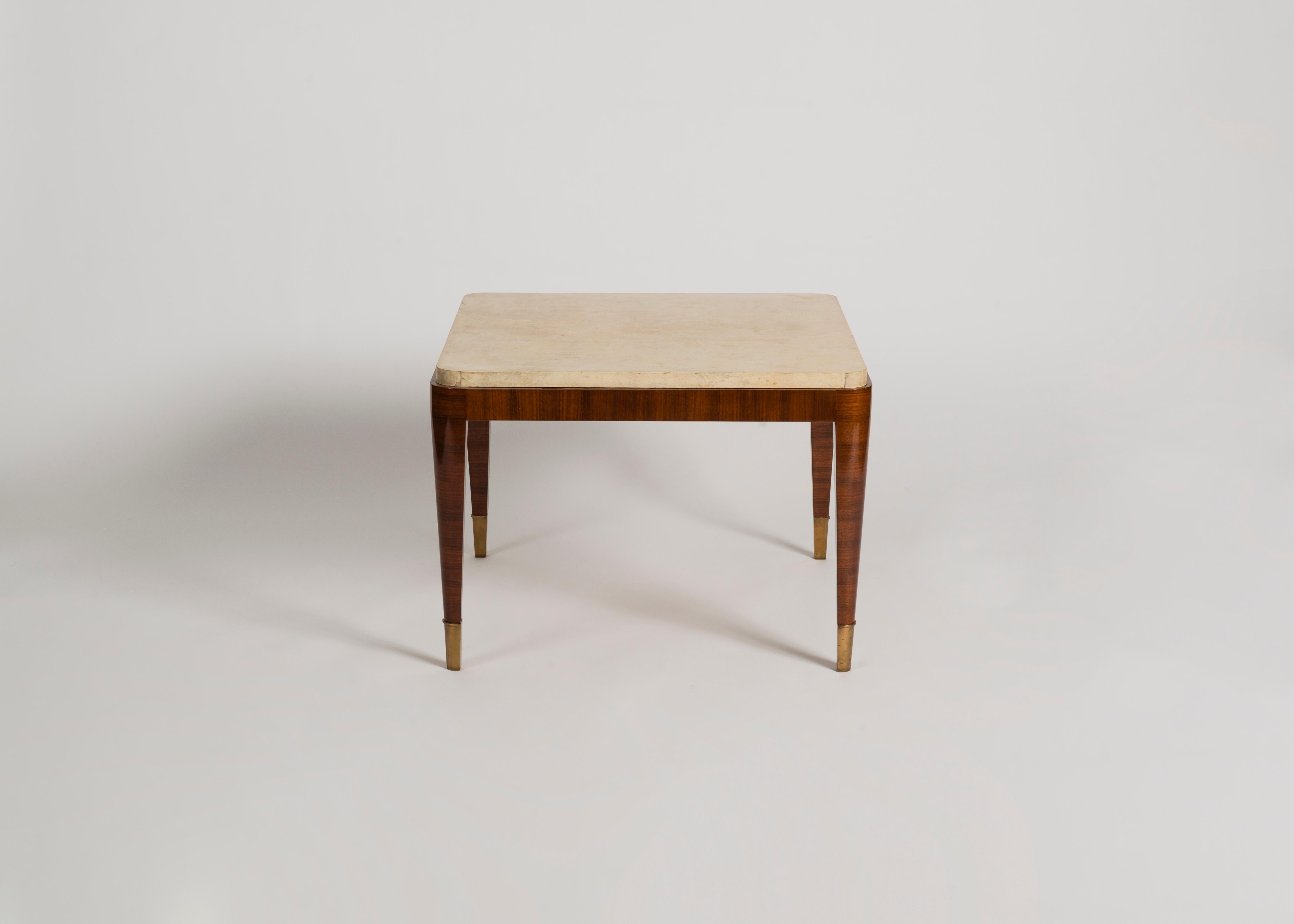 This deco coffee table in striped mahogany, featuring gilt-bronze sabots and a lush parchment top, is remarkable for its fine legs, geometric top, rounded corners, and altogether subtle and delicate
proportions. The parchment top is a probable