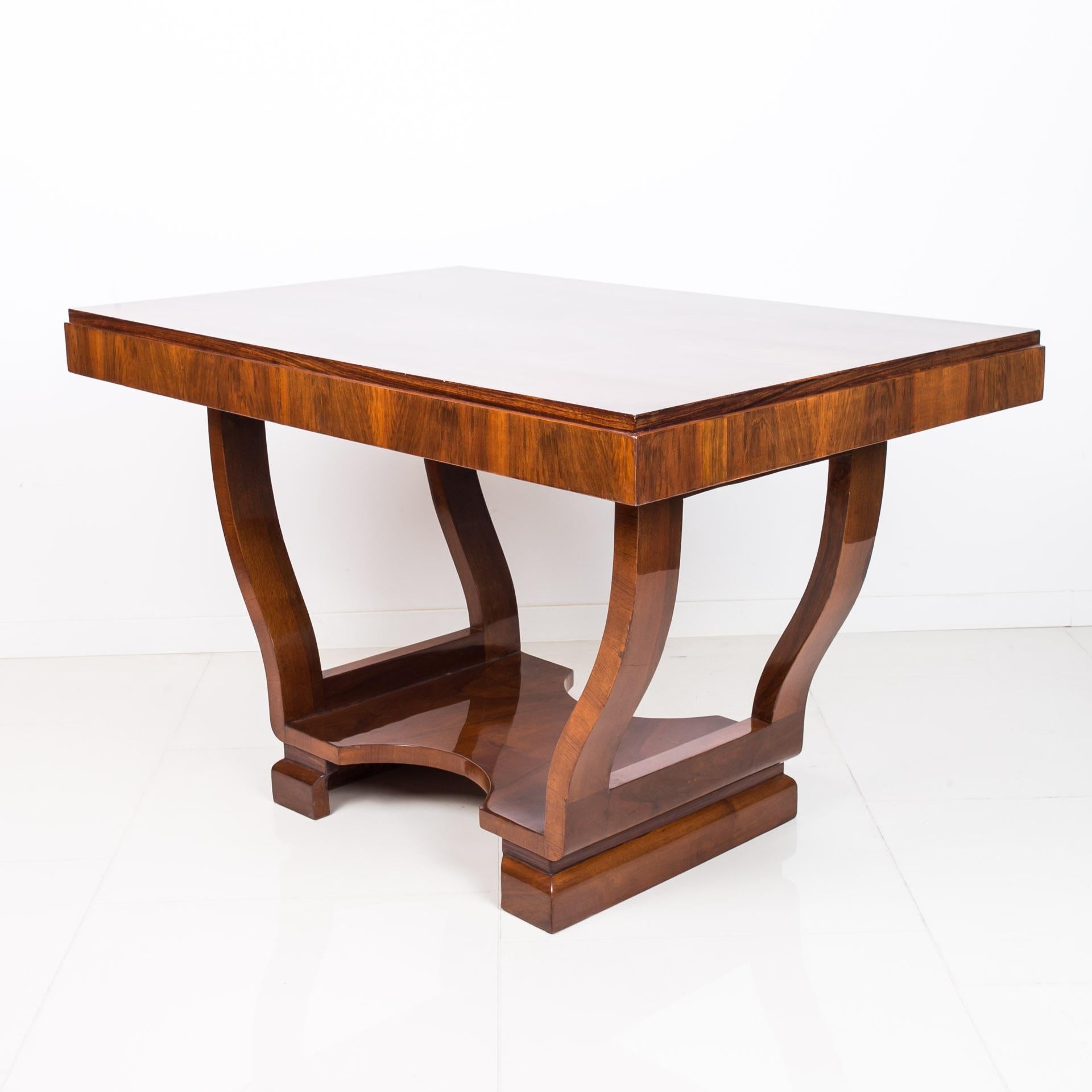 This beautiful Art Deco table was made approximately in 1930s in Czechia, Prague most probably. It features beautifully sculpted base and a top veneered with walnut, varnished to high gloss. The piece has been renovated - all surfaces have been