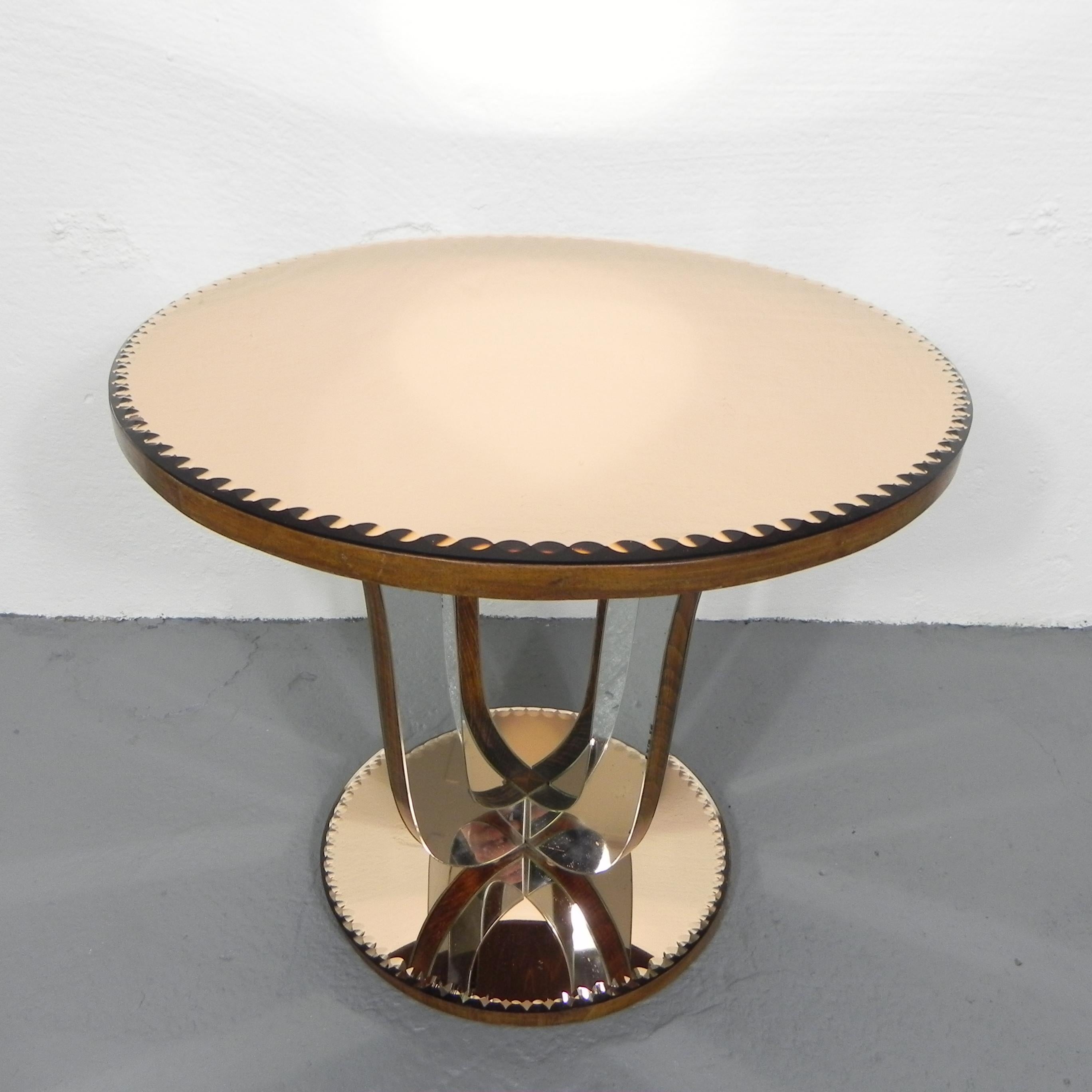 The edges of the salmon-colored glass plates below and
above are faceted in a very special way.
The wooden legs are covered with curved strips of uncolored mirror glass.

Height: 52 cm.
Ø: 59 cm.
There is a small chip in the edge of the top.
There