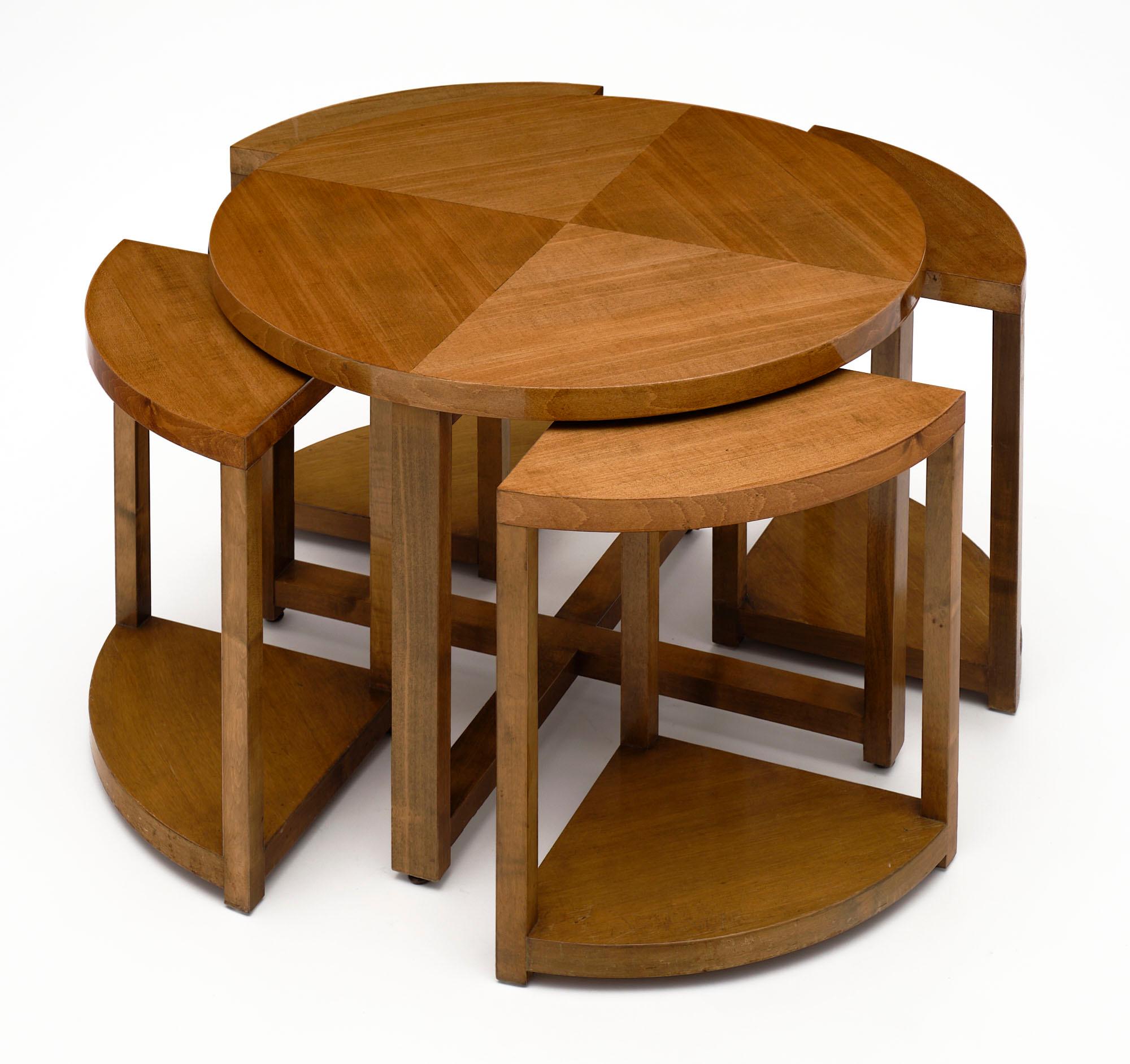 Coffee table from France made of blonde walnut and finished with a lustrous French polish. This table set features a round coffee table with four triangular nesting tables beneath. The measurements for the nesting tables are listed below. 

Each