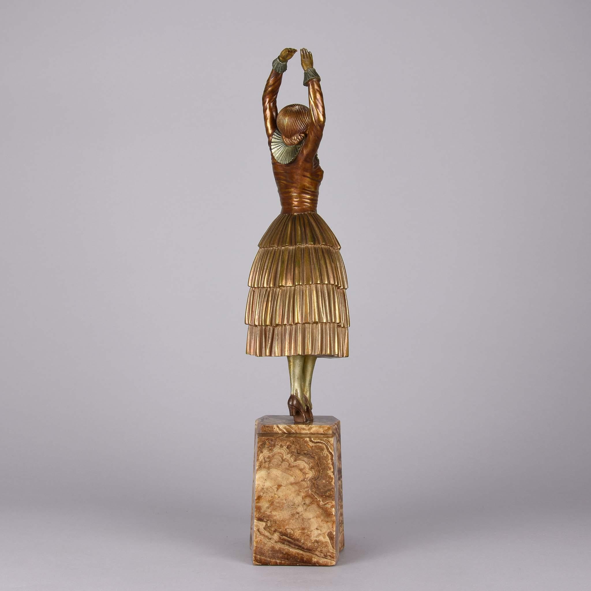A beautiful early 20th century Art Deco cold painted gilt and enamel bronze figurine of a dancer in stretched pose wearing full period attire, signed Chiparus. And raised on a brown and cream onyx shaped plinth.

Ballet at the turn of the century