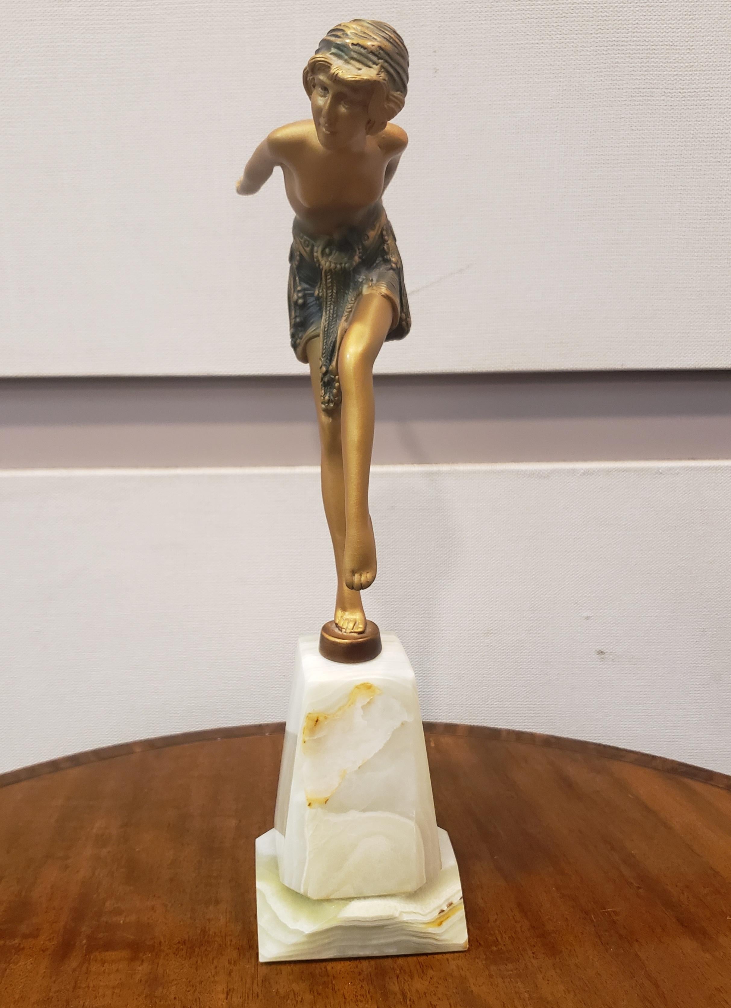 An attractive 20th Century Art Deco cold painted bronze figure of a dancer with her arms rearstretched in an elegant pose. The sculpture exhibits excellent colour and very fine hand finished surface detail, raised on a tower onyx base.