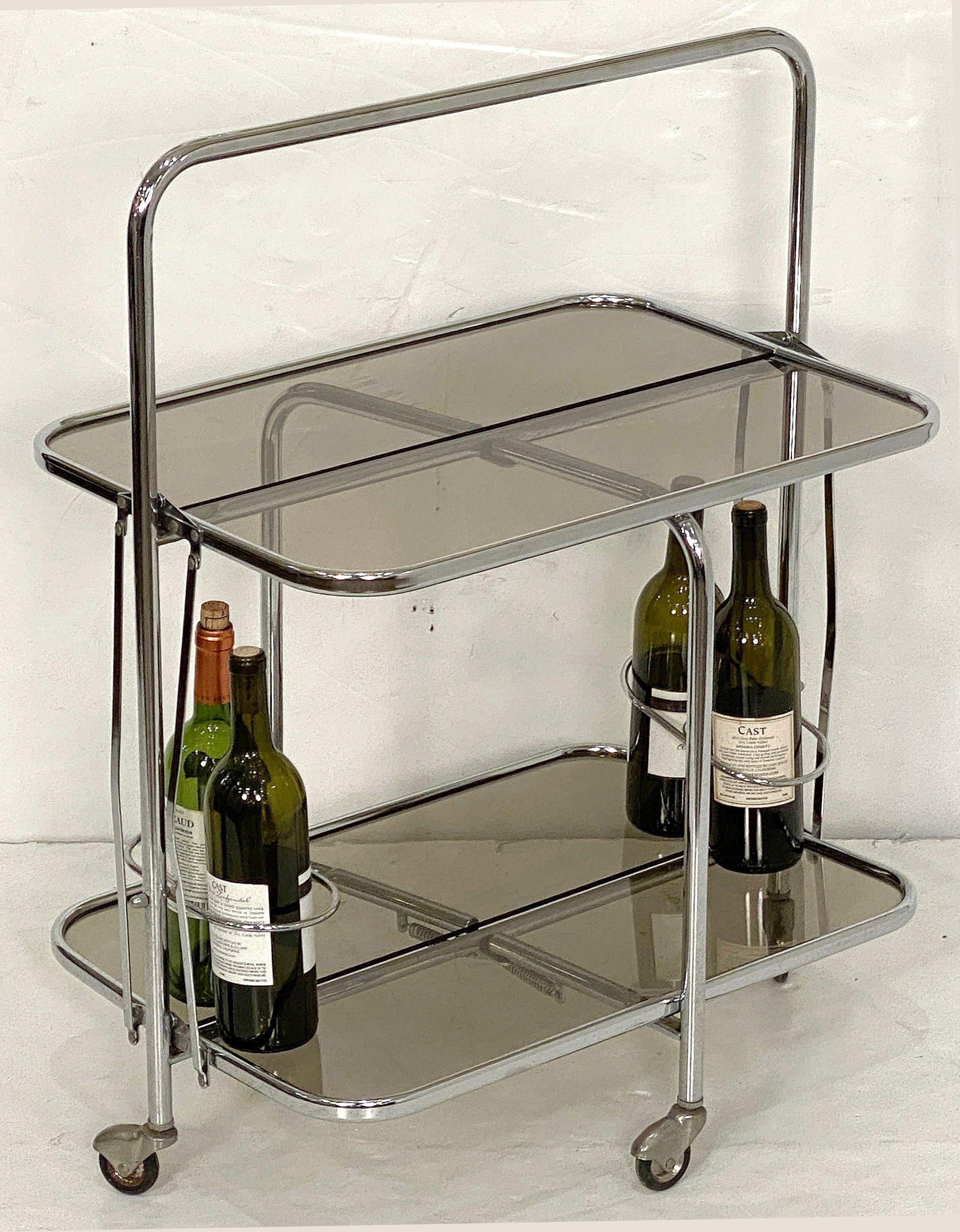 A handsome French bar cart table or cocktail drinks trolley in the Art Deco style, from the Mid-Century Modern period, featuring a chrome frame with two tiers of smoked glass, and optional bottle holders, on rolling casters.

The cart is sturdy and