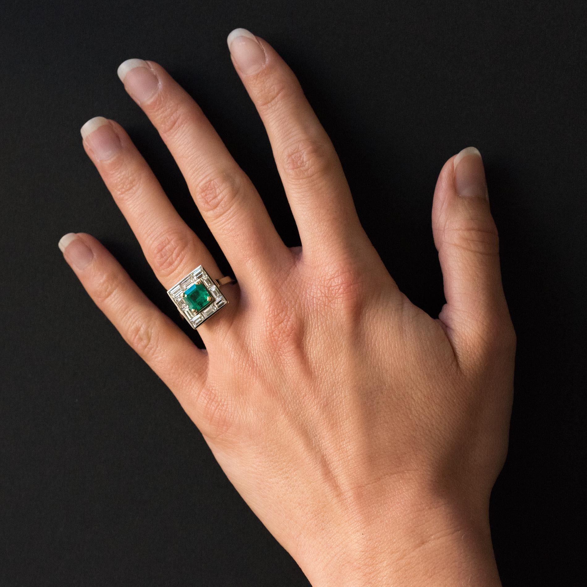 Baume creation.
Ring in 18 karat white gold, eagle's head hallmark. 
This sublime ring holds a claw set square emerald surrounded by 10 baguette- cut diamonds. The geometric style bed holding the diamonds is reminiscent of the Art Deco period.