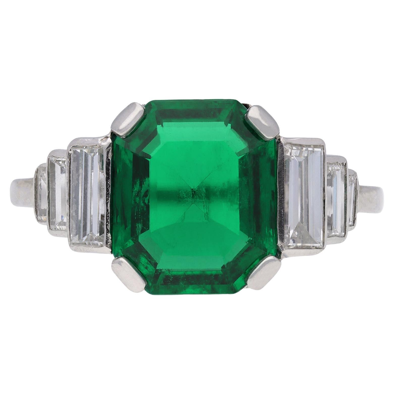 Art Deco Colombian emerald and diamond flanked solitaire ring, circa 1925. For Sale