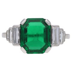 Art Deco Colombian emerald and diamond flanked solitaire ring, circa 1925.