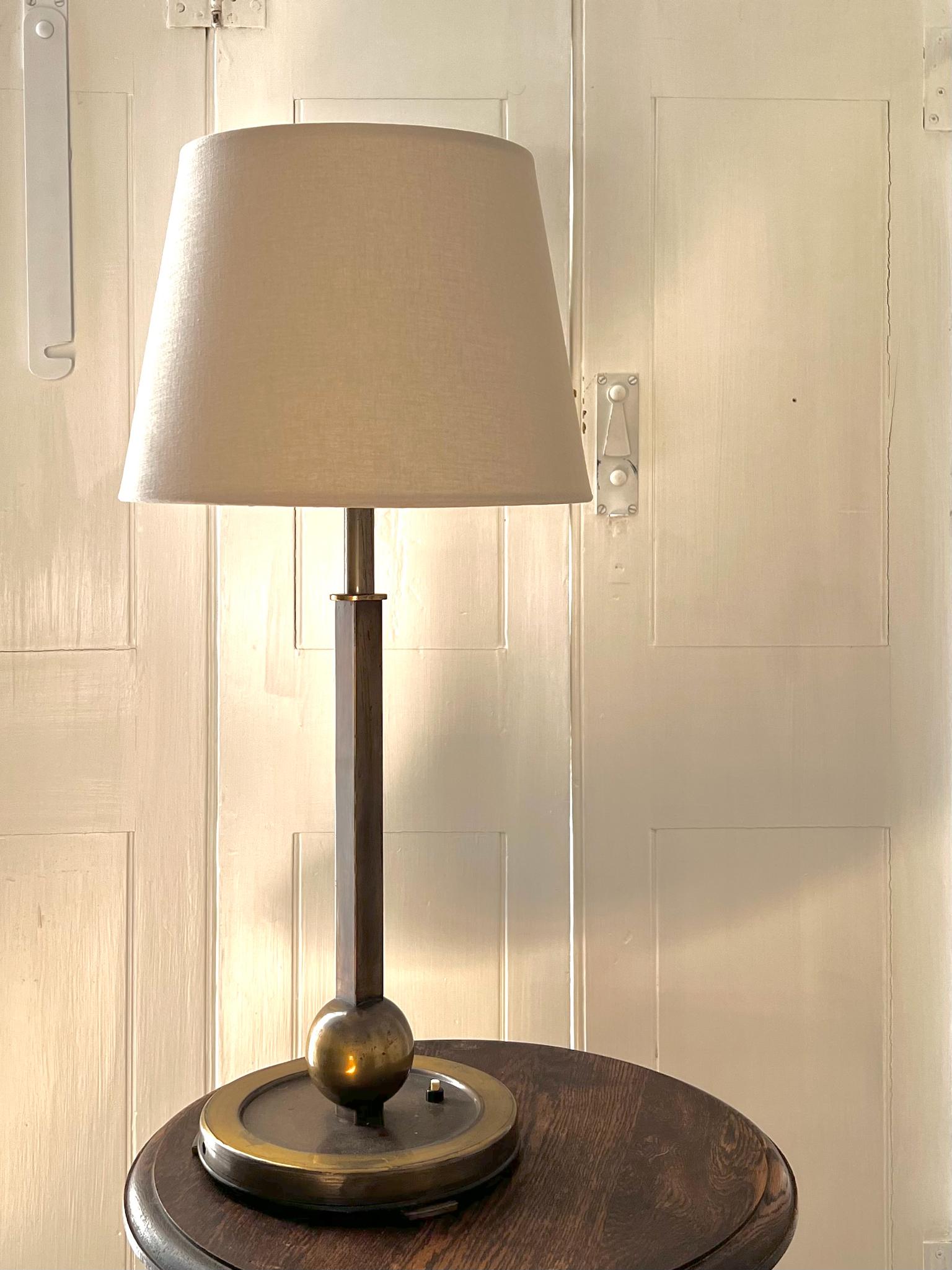 A tall column table lamp, in art deco style. First half twentieth century, found in Belgium, designer unknown.

A simple design of mixed metal with a mellow bronzed finish in brown and deep golden tones, on a heavy base raised on three feet. The
