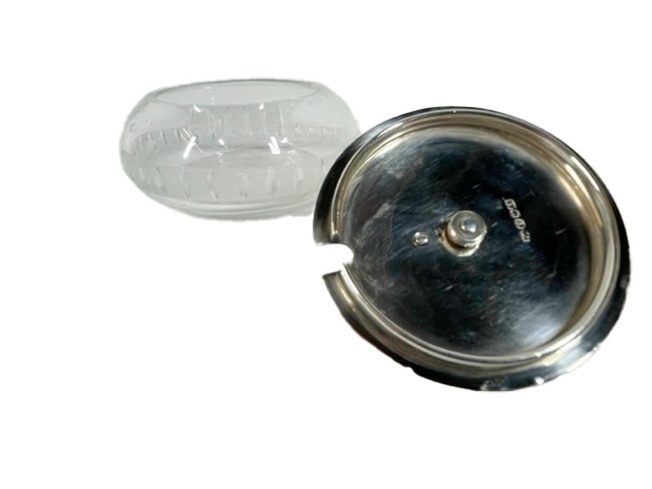 Finly crafted Art Deco cut glass, silver plate and ebony covered condiment / garnish jar / master salt in the form of a curling stone. The compressed ball-form jar encircled with vertical lozenge cuts along a frosted band and having a silver plate