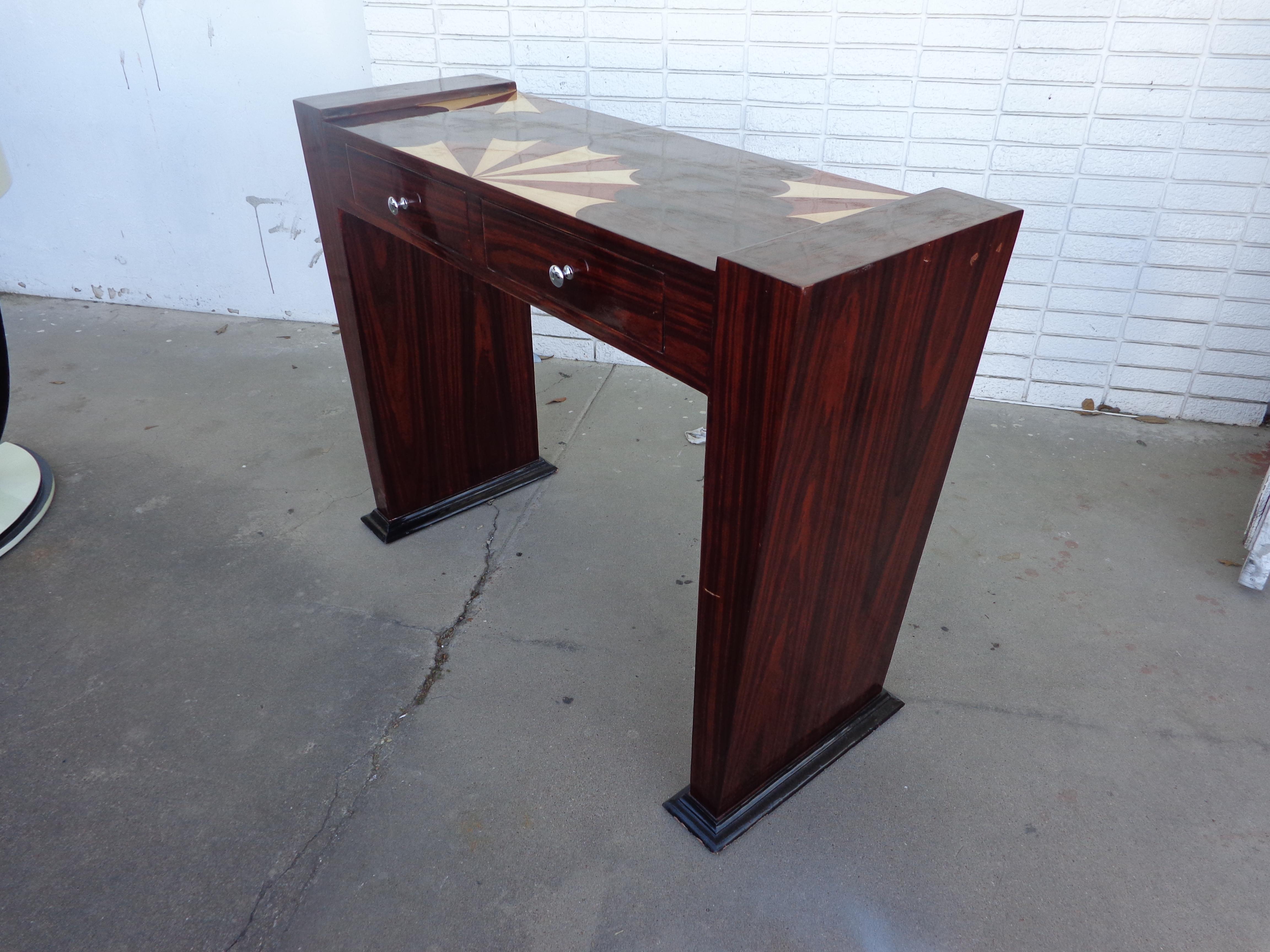 Art Deco console

Art Deco style rosewood console

Exotic wood geometric parquetry design on the top. Ebonized base.
Two drawers with nickel pulls. 

Measures: 47