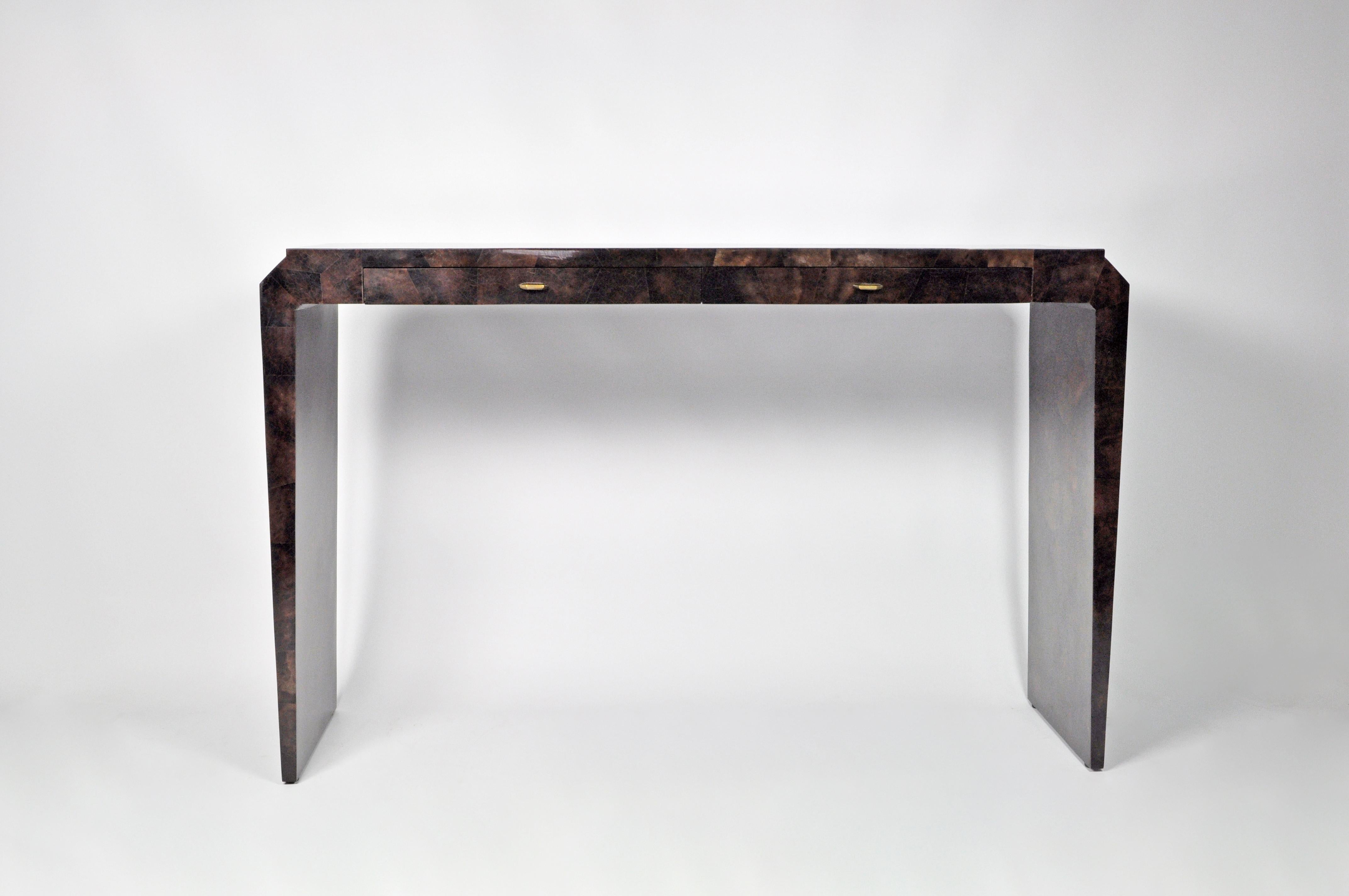 The console table PLUTON is made of a polished shell marquetry in brown colour.
It has two drawers with brass knobs.
The client can chose the colour of the marquetry and this piece can be made with custom dimensions. 
 
The dimensions are 51.18