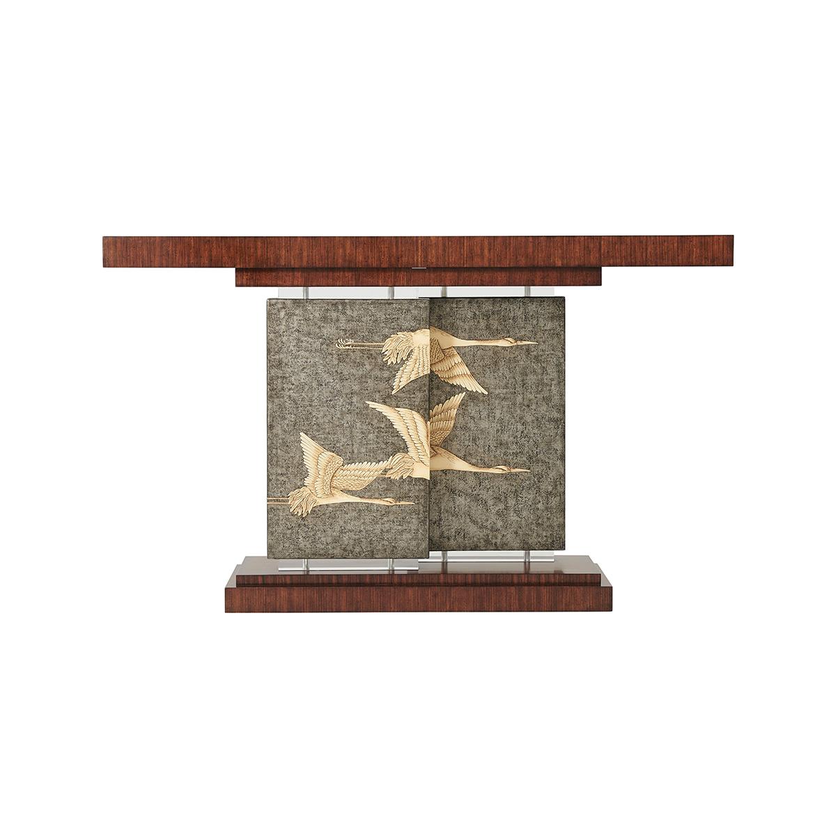 Console de style déco en placage de Hyedua, le plateau rectangulaire soutenu par deux panneaux décalés en Argento étain peints à la main avec des grues volantes et des bases et chapiteaux en acrylique, sur un socle à gradins.

Dimensions : 60