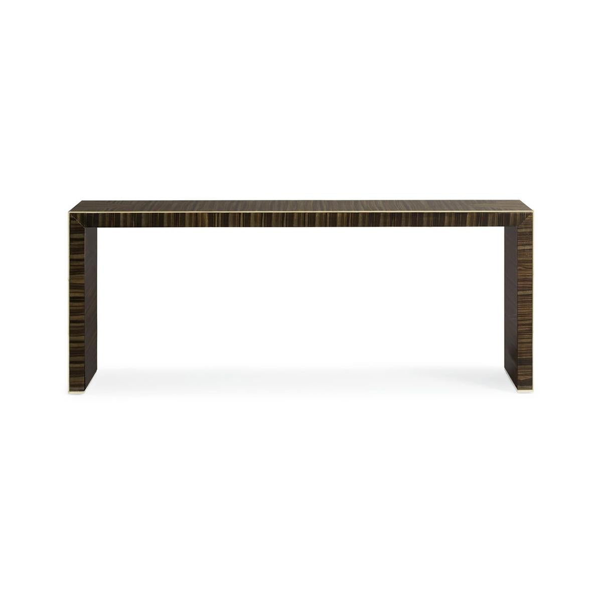 An exotic Striped Ebony veneer is on full display on this modern console. A crisp tailored miter shows off the dramatic veneer on each end panel. A thin, gold metal bead surrounds the entire profile to allow the perfect hint of sparkle.

The