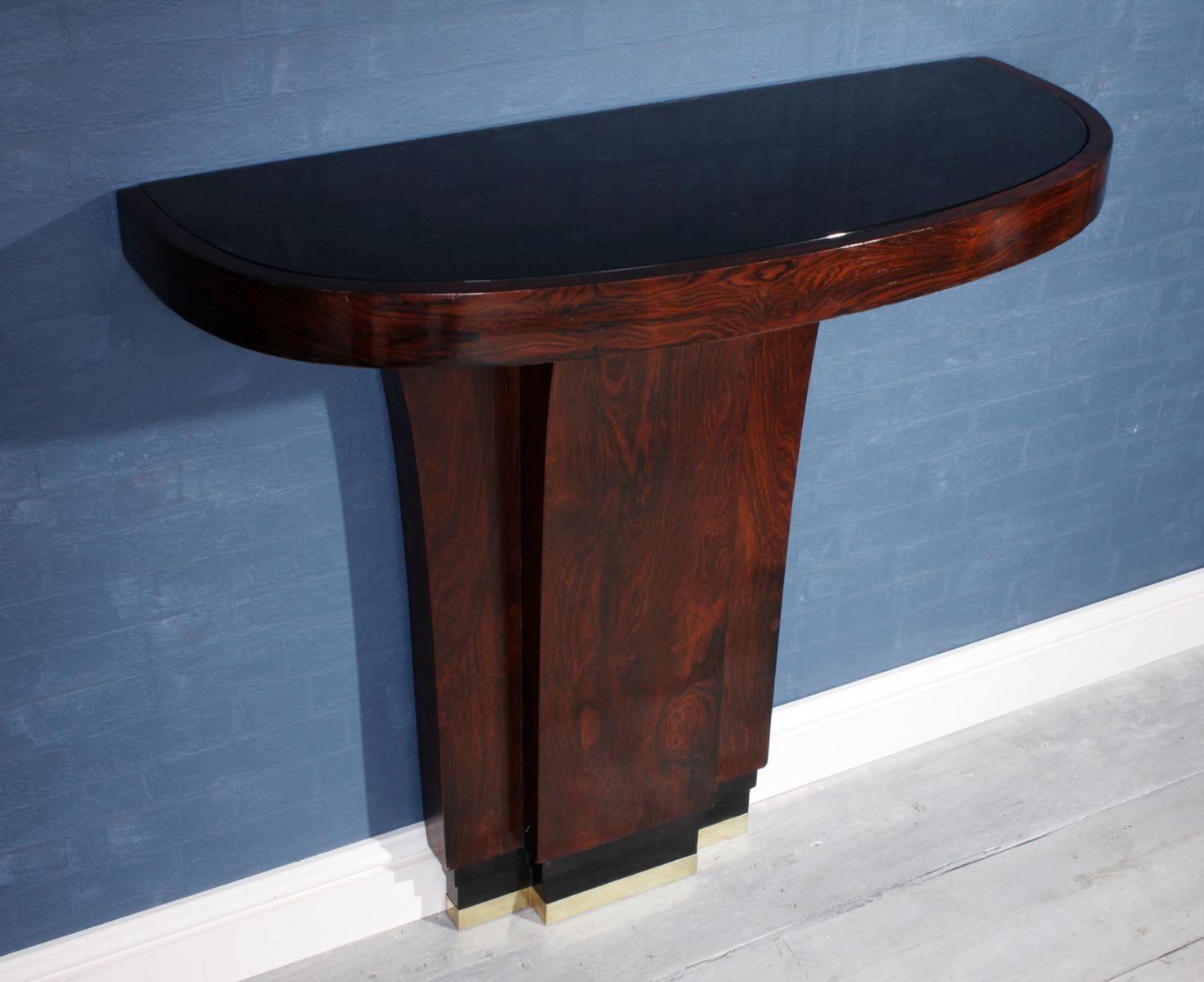 Art Deco console table in rosewood
This elegant console table was produced in France in the 1930's in Rio rosewood it has a polished bronze foot and black glass top this has two brackets underneath where it will need to be fitted to the wall, it