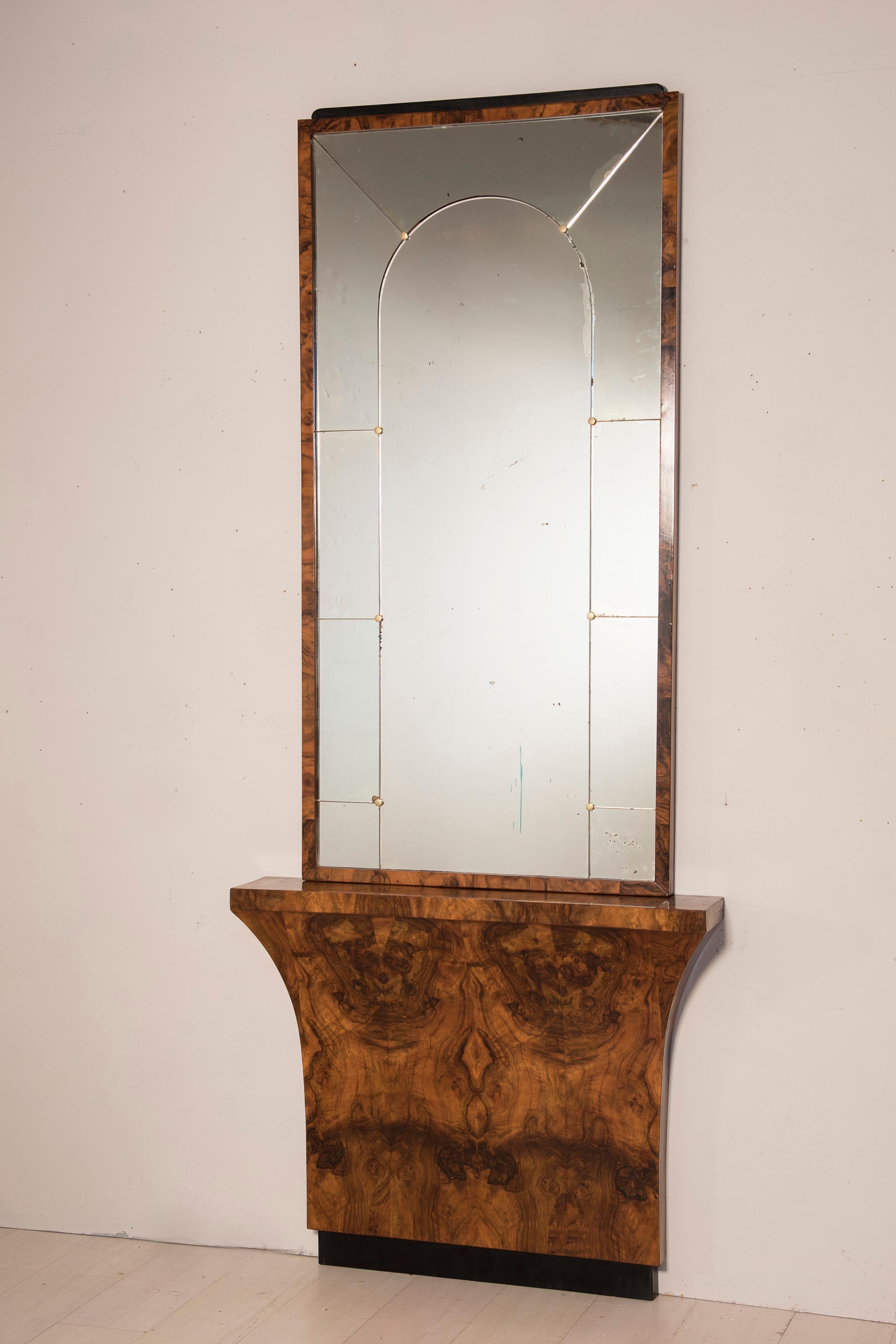 Art Deco 1930er Jahre furnierter Konsolentisch mit Spiegel. Der Sockel des Konsolentisches ist mit einer großen Furnierflamme versehen. Der Spiegel ist mit Messingnägeln getäfelt.
Größe des Sockels 100 x 18 h 82 cm - Größe des Spiegels 157 x 80