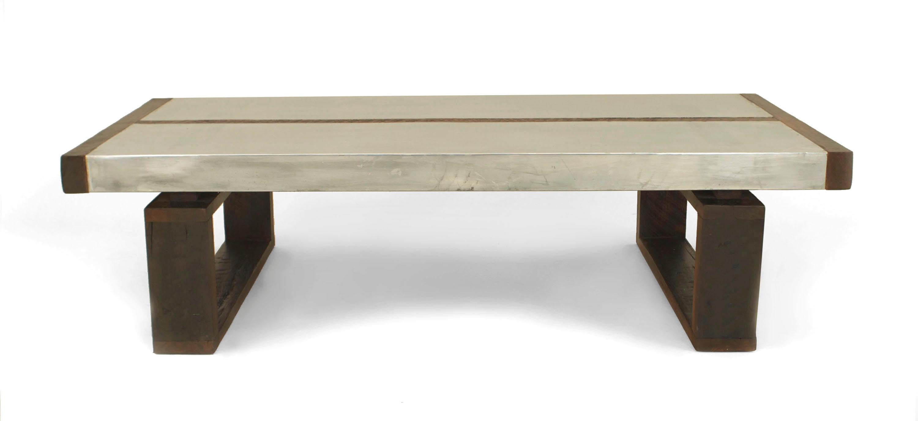 Art Deco style rectangular coffee table with stained oak sides and a top with a center strip separating two metal panels resting on two open pedestal base sides.
 