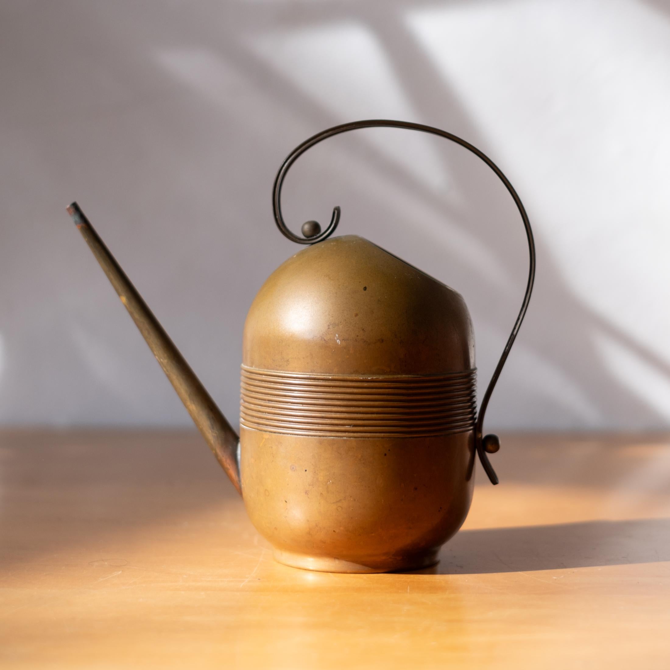 Art Deco copper and brass watering can. Manufactured by the Chase Brass and Copper Company in the 1930s. Signed on the bottom with the Chase Centaur logo. Water tight. USA, 1930s. 
