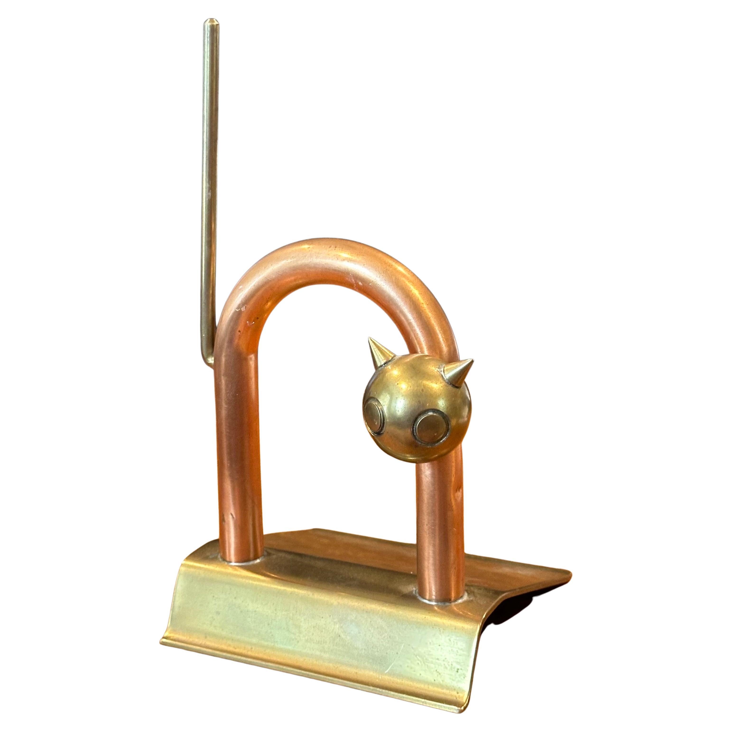 Une très belle et difficile à trouver butée de porte pour chat Art Déco en laiton et cuivre par Walter Von Nessen pour Chase & Co, vers les années 1930. La pièce est en état d'origine avec une belle patine, une légère oxydation, quelques rayures de