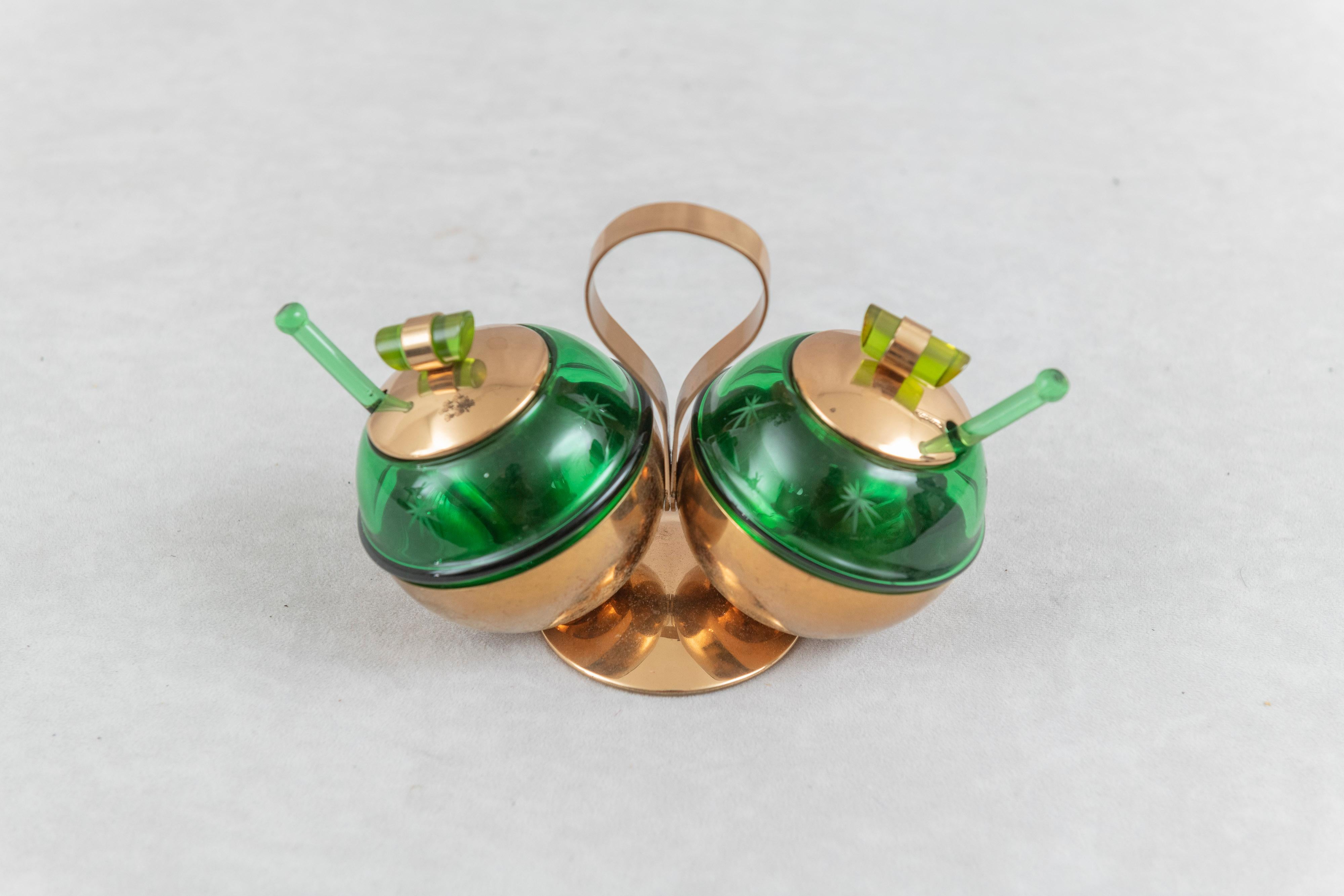 This very striking double condiment set really caught our attention. Admittedly this is something we rarely buy, but just one look made us buyers. The commitment to the art deco style with the green glass and copper is an eye catcher. Having all the
