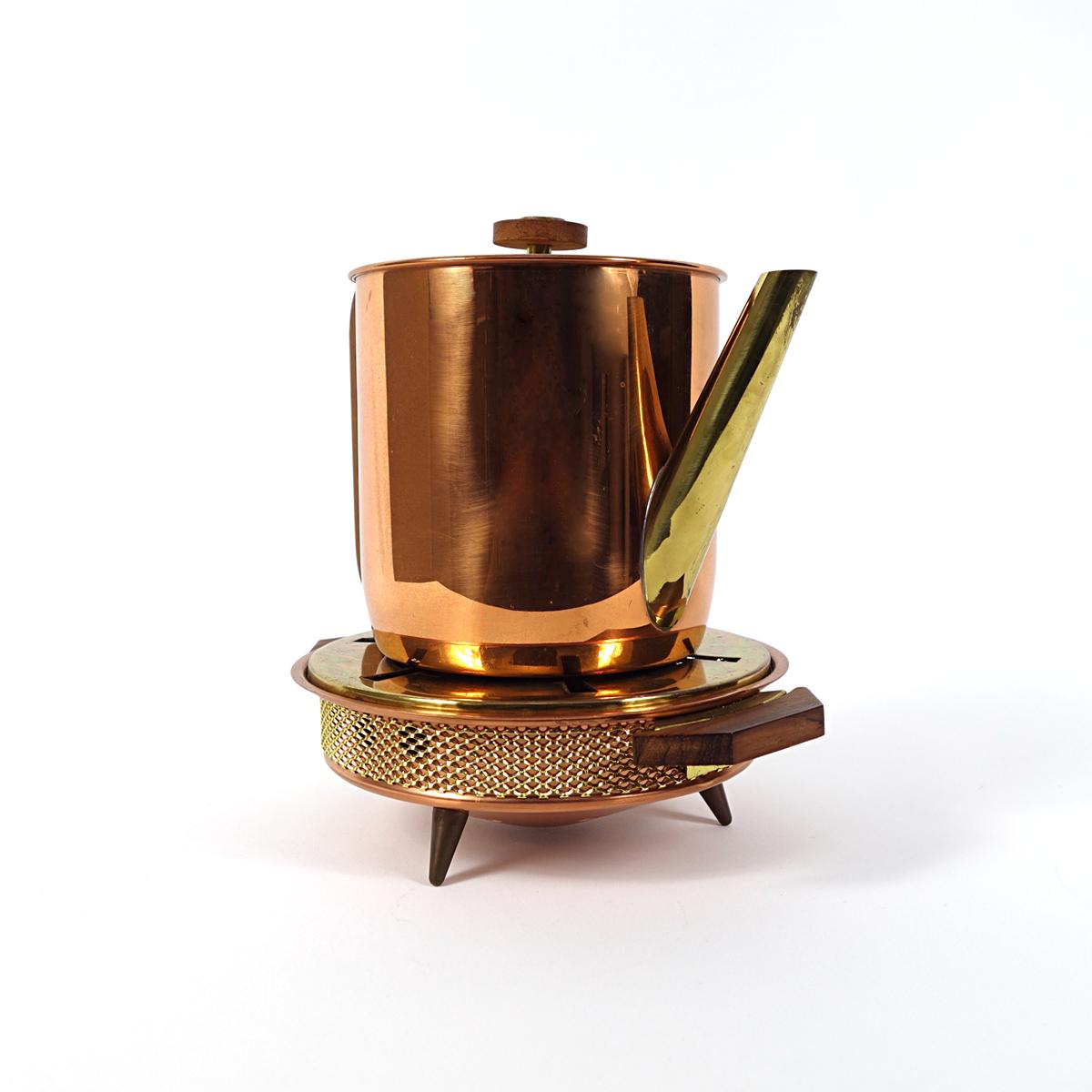 Subtly styled copper teapot with wooden lid and handle, plus matching tea light, in Art Deco-style.

Beautiful design for this very rarely used tea pot with its graceful wooden handle and wooden ring around the copper of the lid cap, allowing for