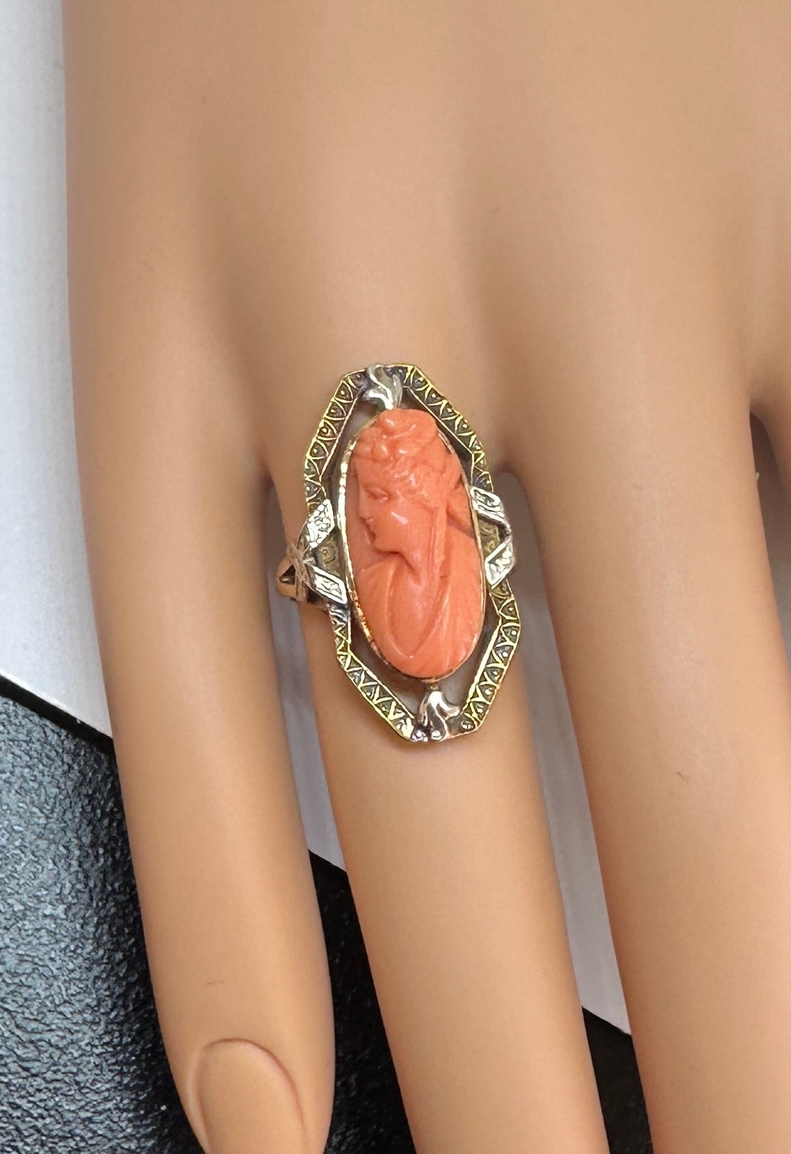 Il s'agit d'une superbe et rare bague ancienne Art Déco - Victorienne - Belle Epoque en camée corail avec une image sculptée à la main d'une déesse femme classique sertie dans une magnifique monture en or jaune et blanc ajouré d'une beauté exquise. 