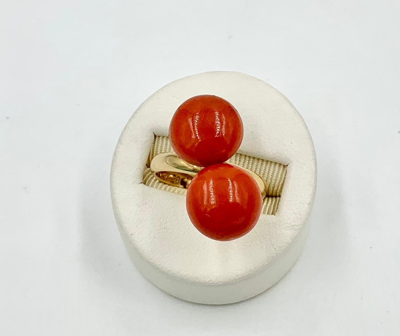 A magnificent original Art Deco Ring with two beautiful natural round Red - Salmon Coral Cabochons set in a stunning Art Deco design in 14 Karat Gold.  The ring is a masterpiece of the Art Deco period with its dramatic color and style yet very clean