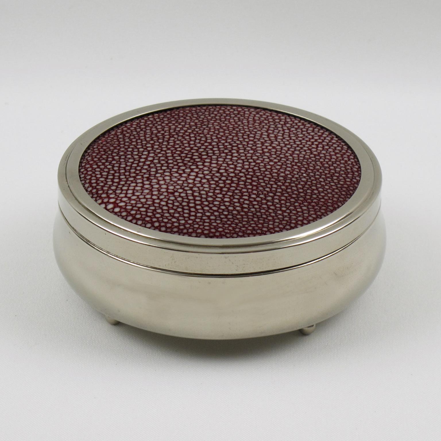 Lovely Art Deco round lidded box. Chromed metal round geometric shape with rare real red shagreen lid. Interior in blue velvet and tiny chrome ball feet.
Measures: 4.50 in. diameter (11.5 cm) x 1.57 in. high (4 cm).