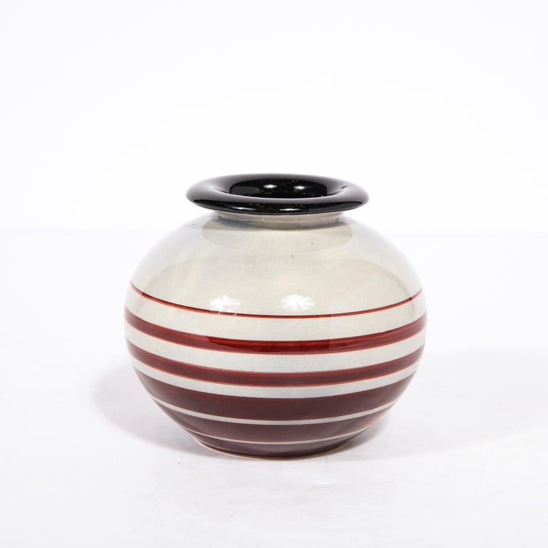 This elegant Art Deco ceramic vase was realized by the celebrated designer Ilse Claesson for Rörstrand in Sweden circa 1940. It features a rotund body finished in a sumptuous cream glaze with a protruding mouth that cantilevers subtly over the