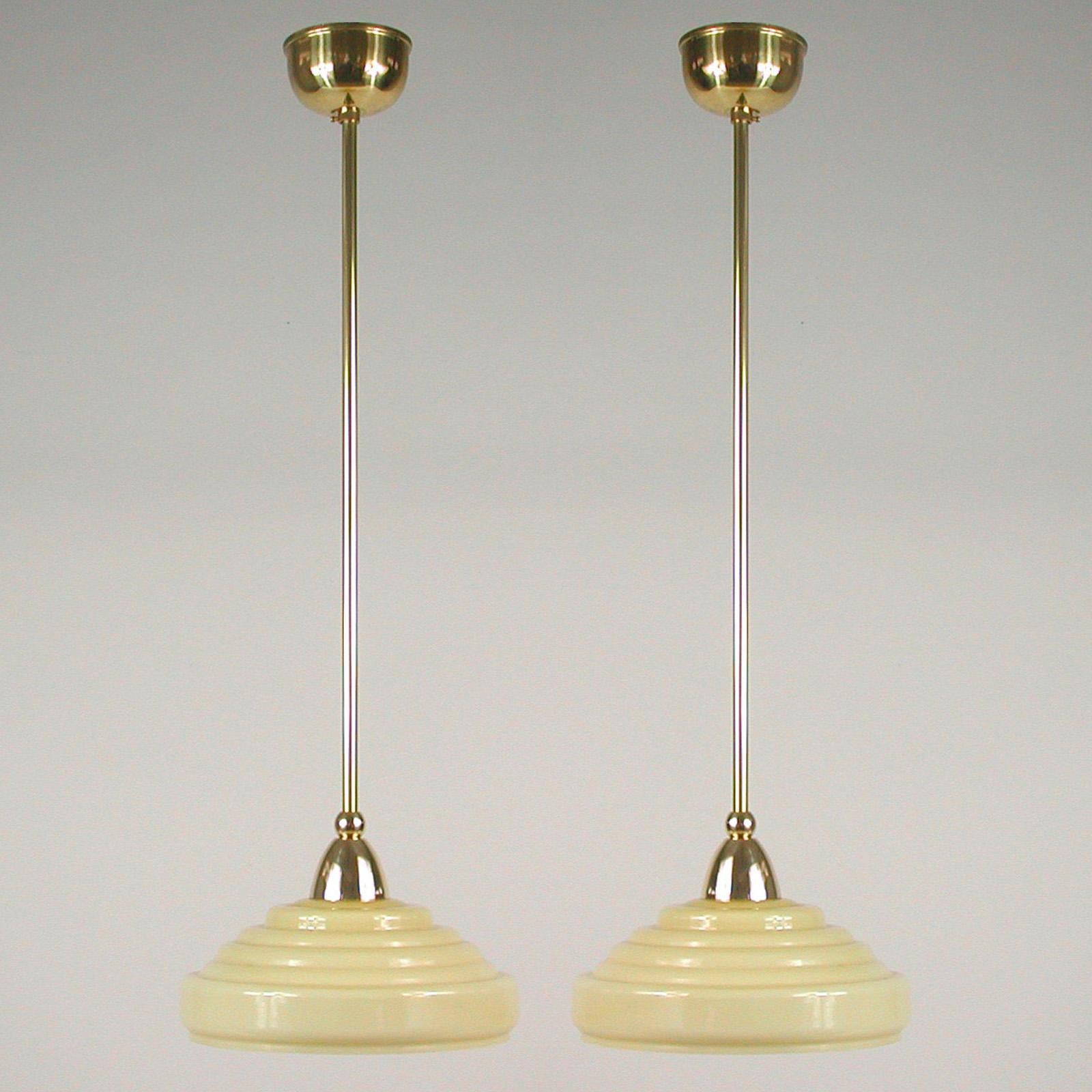 These elegant pendants were designed and manufactured in Sweden in the 1940s. The lamps feature cream opaline glass shades and brass hardware. Good vintage condition with one E14 socket each.

The lamps have been rewired and re-electrified for use