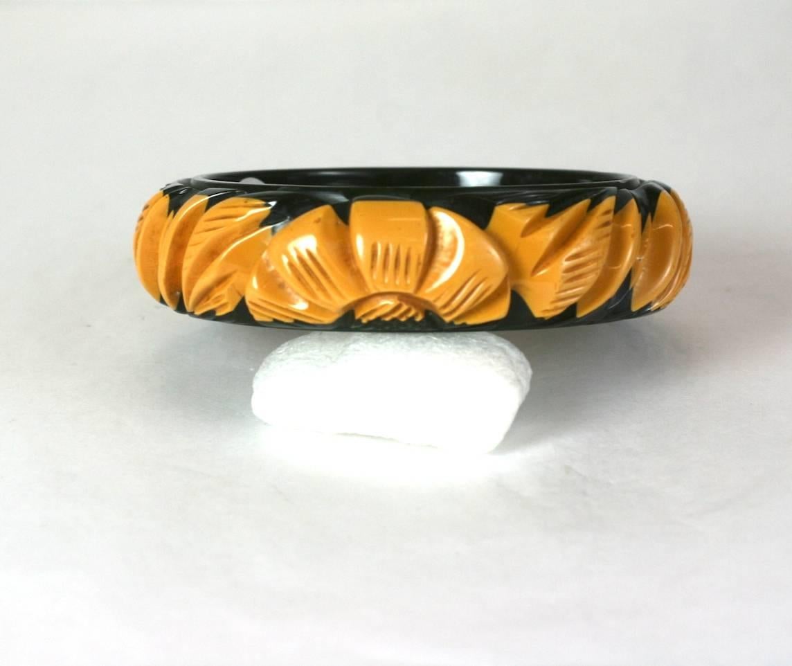 Rare Art Deco cream to black laminated, deeply carved and incised bakelite bangle with abstract flower heads and leaf motifs from the 1930's. USA. 
Excellent Condition.
Width 7/8