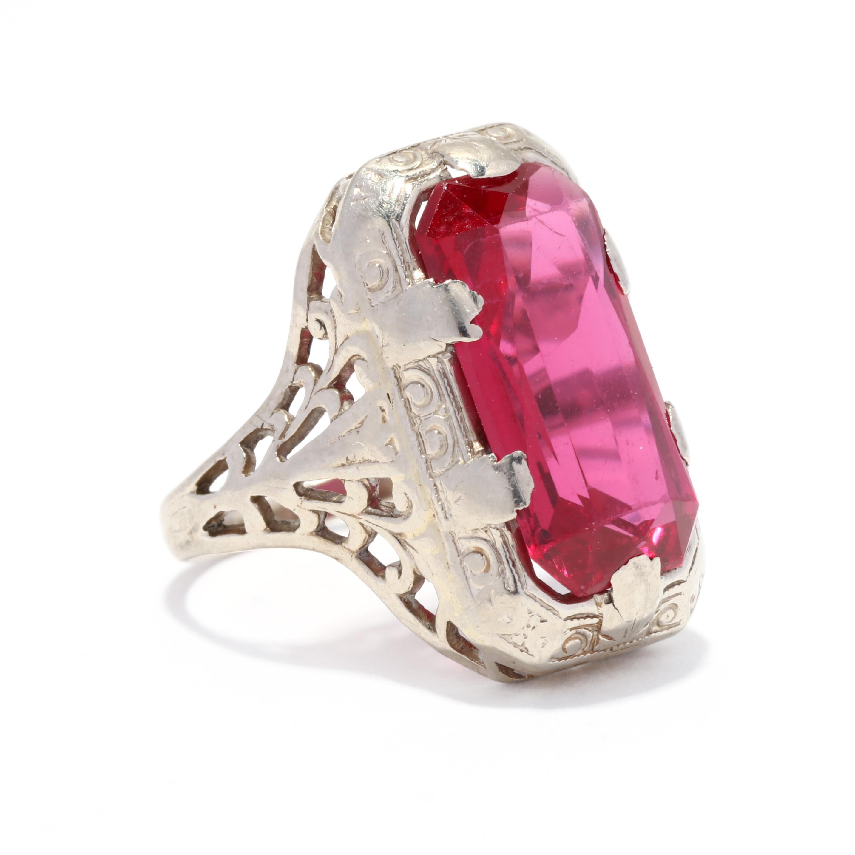 An Art Deco 14 karat white gold created ruby filigree ring. This ring features a prong set, rectangle emerald cut created ruby weighing approximately ? carats, set in a floral engraved and filigree mounting.

Stones:
- created ruby, 1 stone
-
