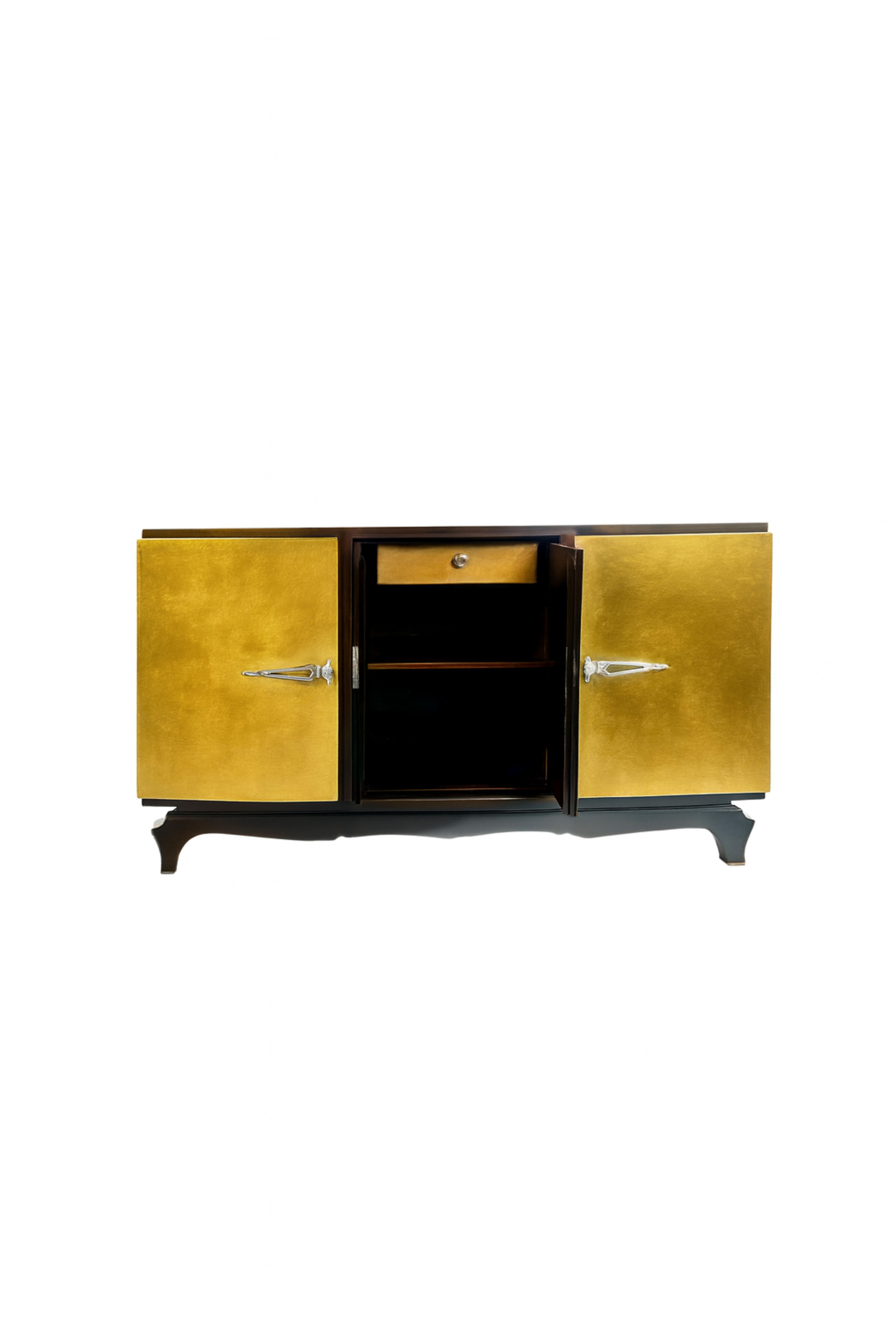 This stunning Art Deco gilted sideboard credenza, crafted in the 1930s, embodies the elegance and sophistication of the era. Blending American influence with French flair, the piece features chromed handles and hardware that gleam against its rich