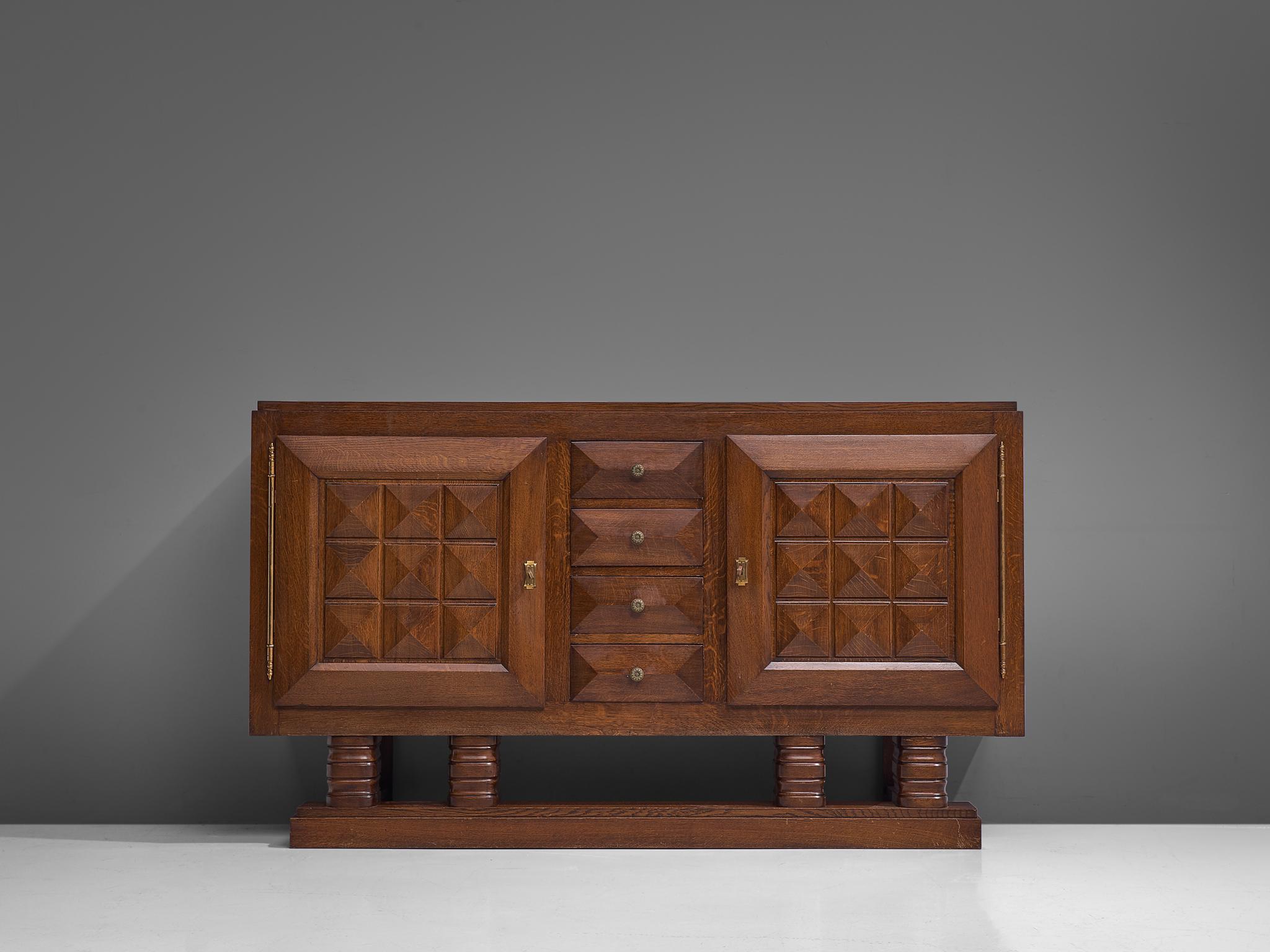 Gaston Poisson, credenza, stained oak, France, 1930s. 

Sturdy sideboard in oak with graphical door panels and drawers. The sideboard is equipped with several shelves and four drawers which provide plenty of storage space. The door panels and base
