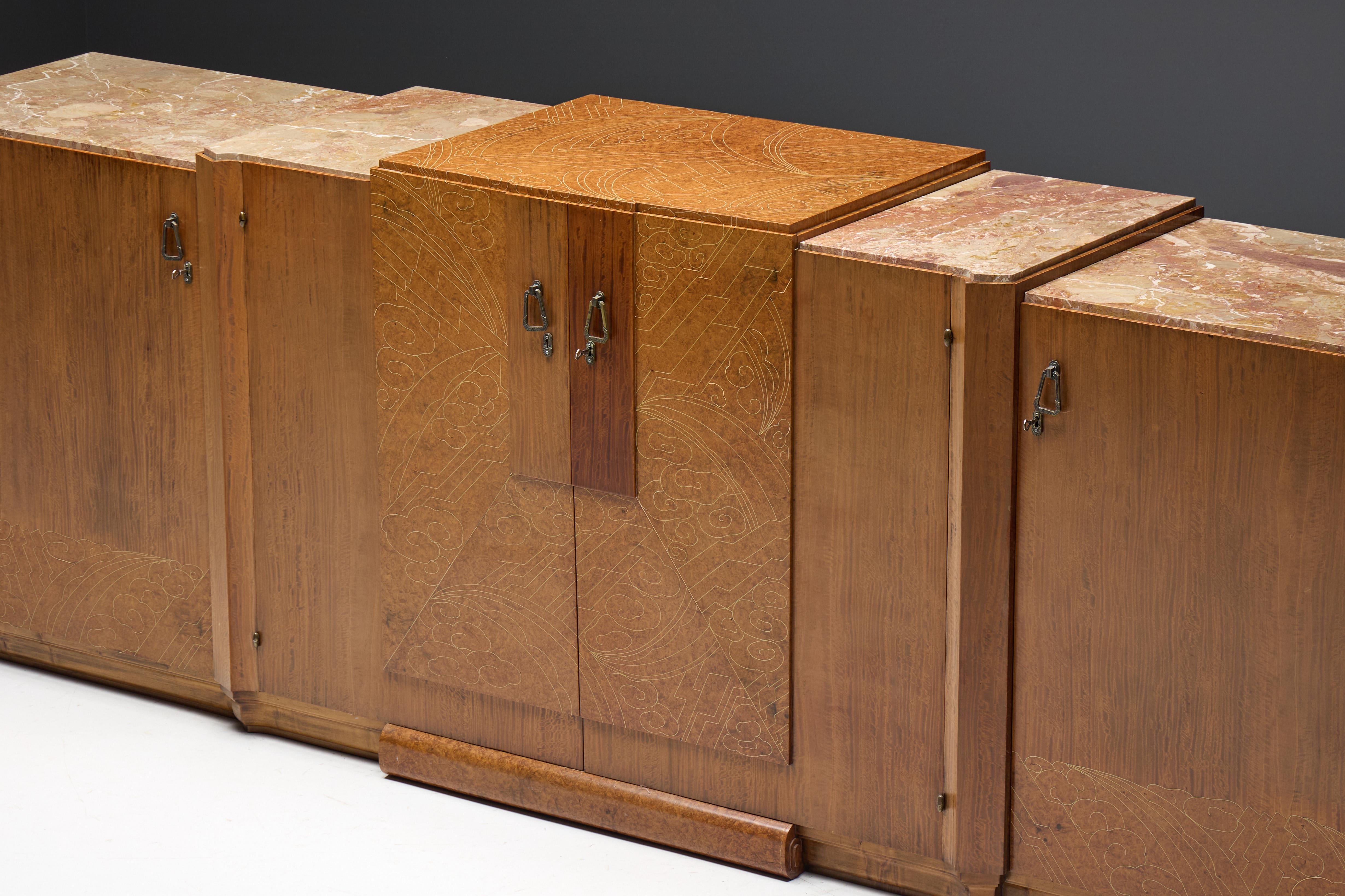 Ce buffet Art déco, fabriqué en France dans les années 1930, est une pièce sophistiquée qui illustre des matériaux luxueux et un savoir-faire extraordinaire. Avec un mélange harmonieux d'acajou riche, de bois de ronce et de marbre élégant, cette