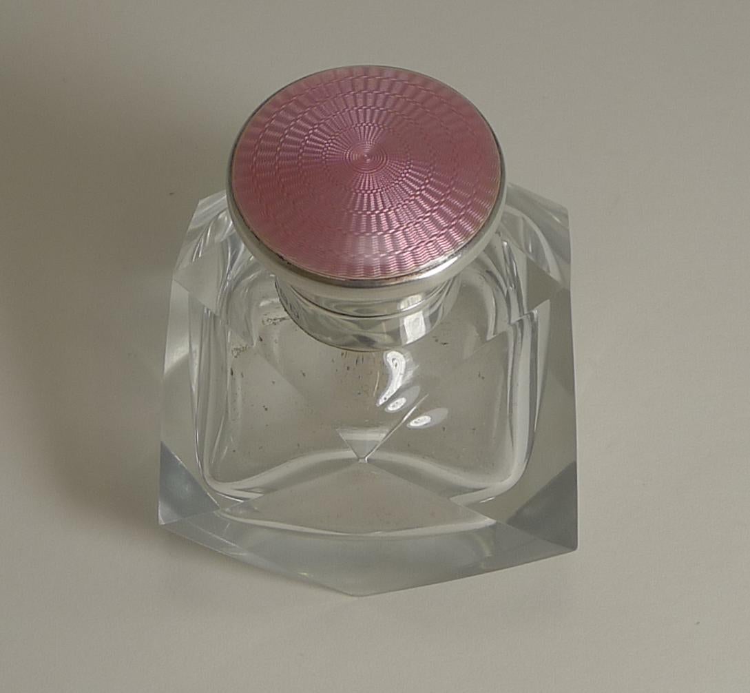 Pretty as a picture, this vintage scent bottle is made from a heavy piece of English crystal with an unusual geometric cut with angular facets.

The sterling silver lid is hinged and once opened reveals an interior washed in gold and the original