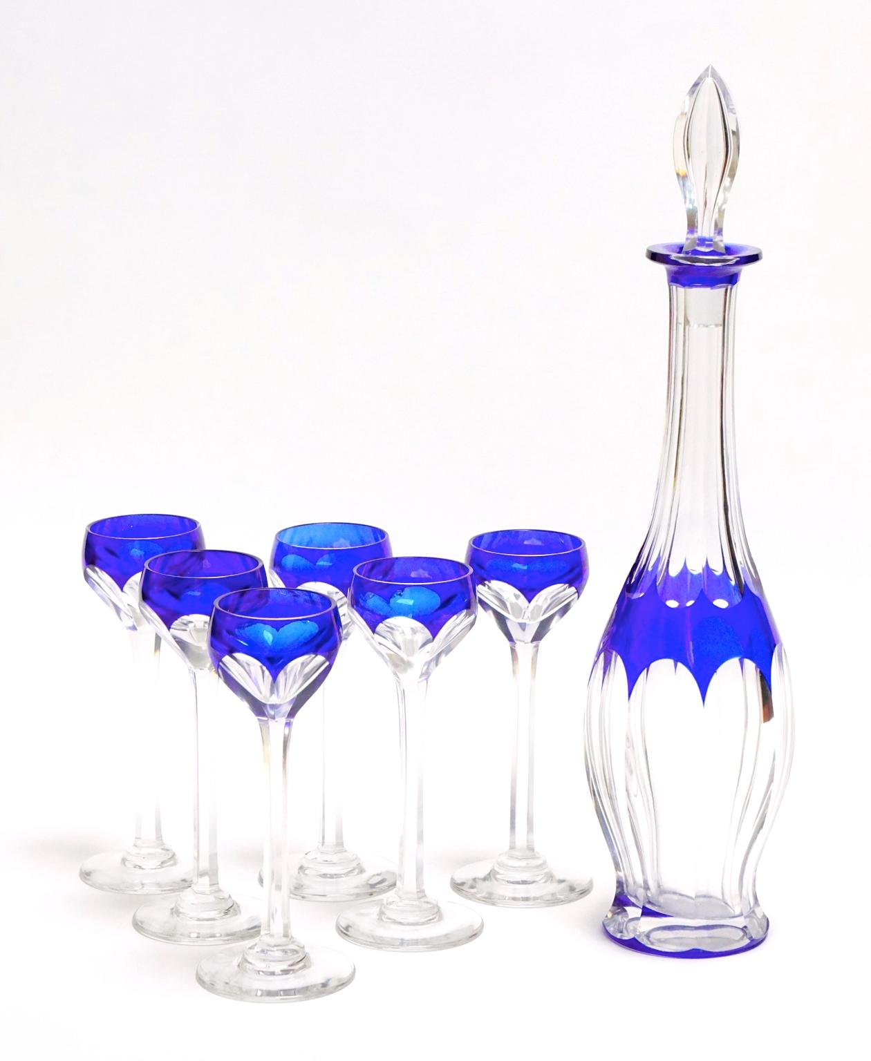 A crystal decanter in blue overlay set with six glasses in very good condition. Original stopper. 
Size:
Decanter, height 31.5 cm, diameter 6.5 cm.
Eight glasses, height 13.5 cm, diameter 4 cm.