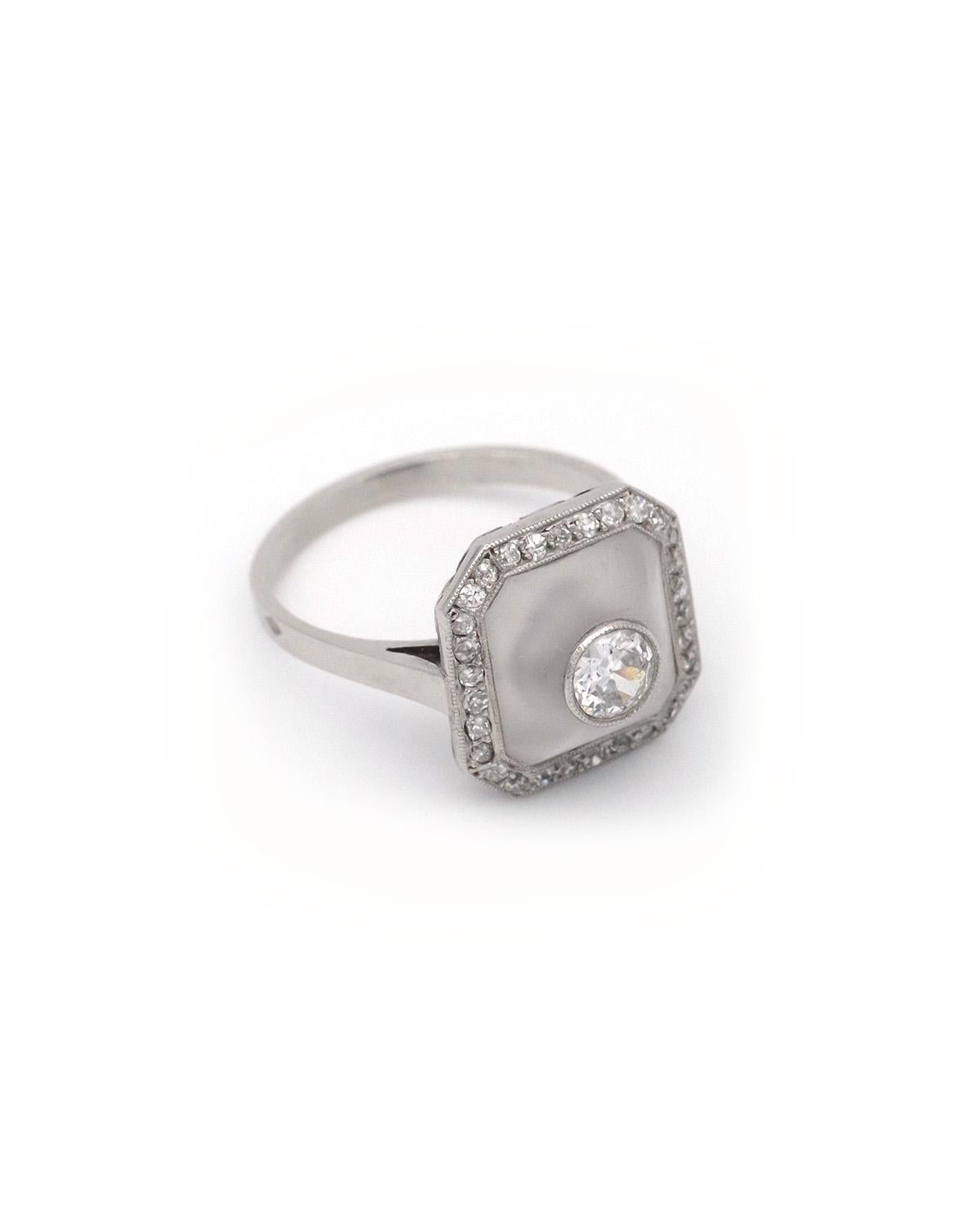 Art Deco rock crystal ring in platinum and 18 karat gold. A 1930s ring centered with a 0.25-carat old-cut diamond, set in a carved and frosted rock crystal, in the shape of a dome. The motif is enclosed in a diamond surround. The ring has an