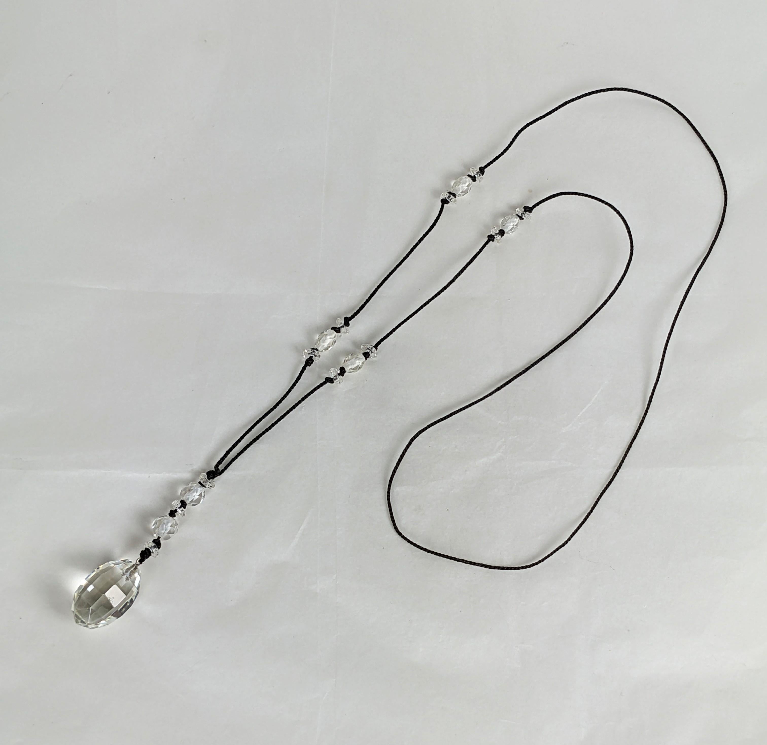 Sautoir de cristal Art Decó de los años 20 en Francia. Cordón de seda con rondeles de cristal, cuentas facetadas y gota central colgante. 
Cordón 30