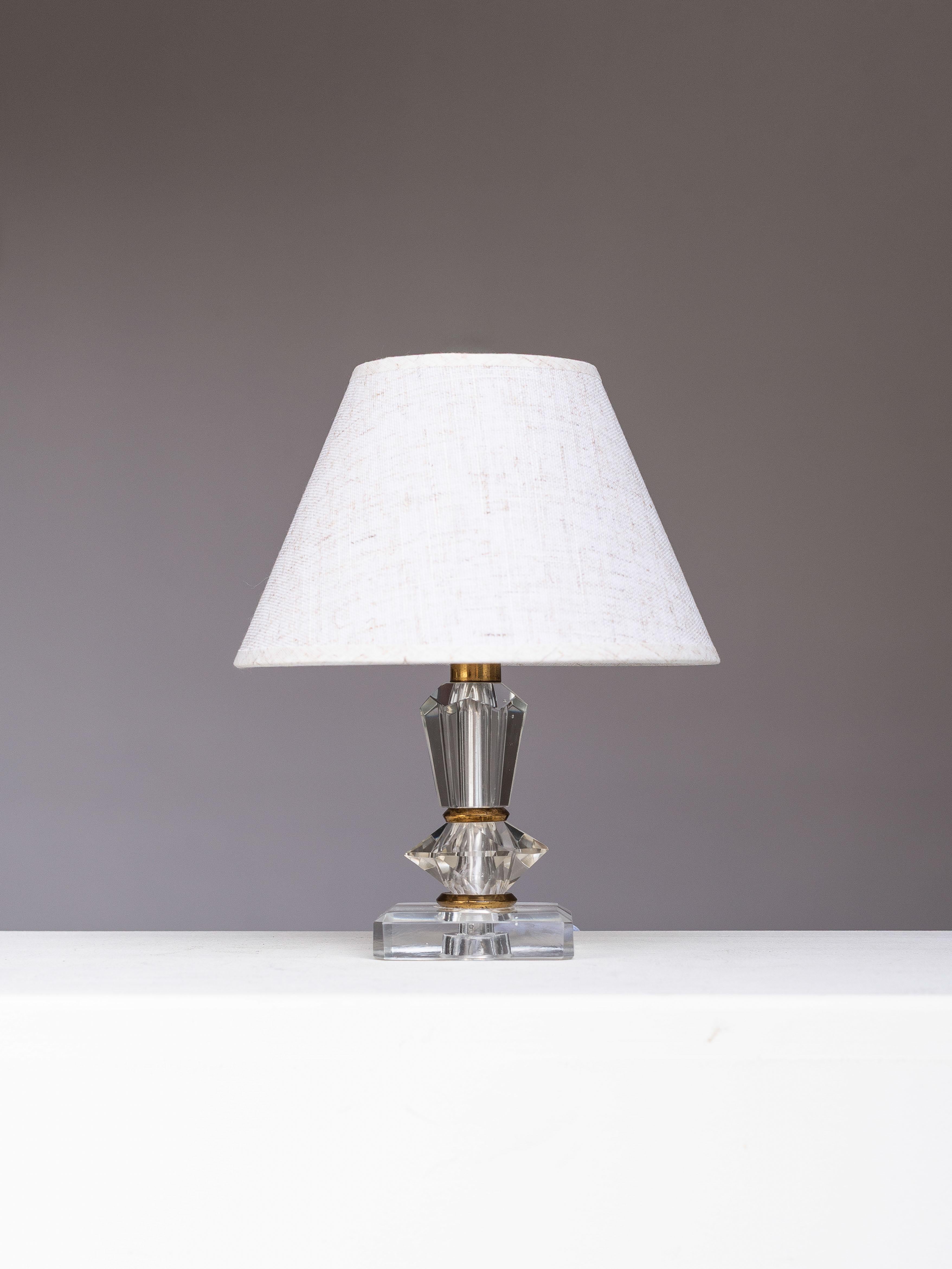 Art Deco Crystal Table Lamp - Hollywood Regency - France 1940s

Elegant Art Deco lamp made of crystal faceted shapes and brass.

The crystal base captures and reflects the light beautifully,.

The lamp has been fully rewired and is in perfect