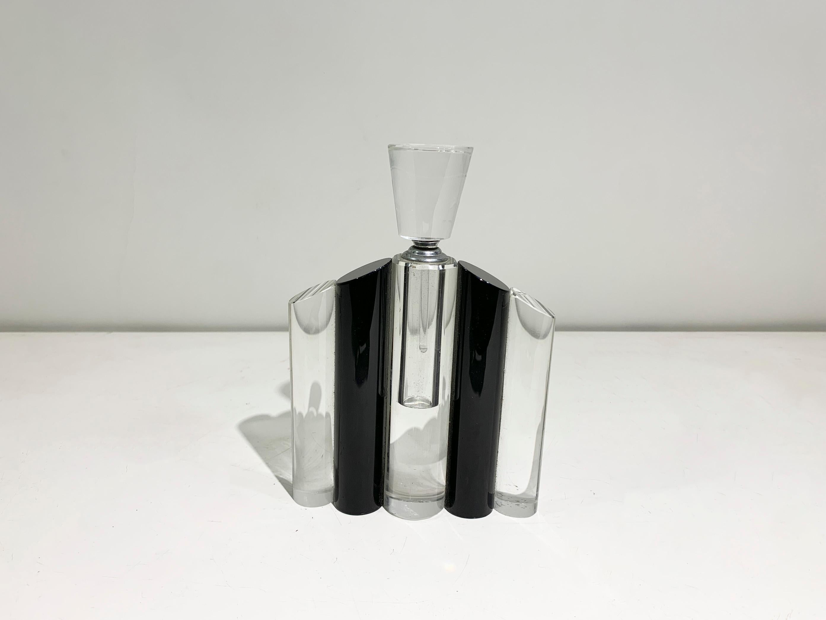 Questa bottiglia di cristallo Art Deco presenta un sorprendente disegno geometrico che incarna l'eleganza e l'audace simmetria caratteristica del movimento Art Deco. La bottiglia è composta da vetro trasparente e nero, creando un contrasto