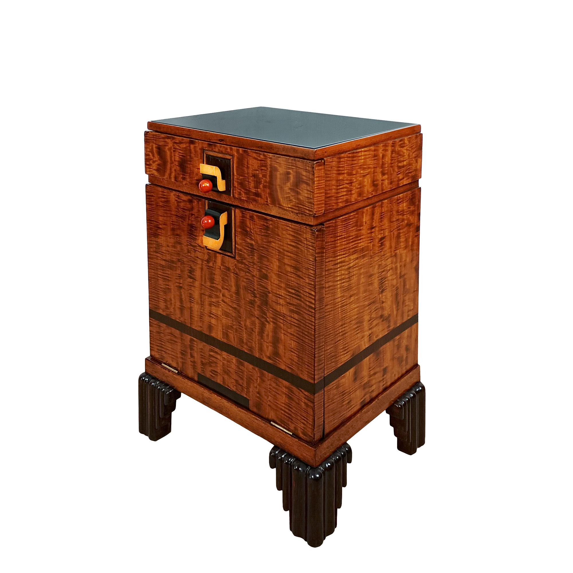 Art Deco cubist bedside table in lemon veneer with mahogany rods, stained beech legs, pearwood and black lacquer handles on the drawer and flap door, coral-red bakelite knobs. Black opaline top. French polish.
Spain, Barcelona circa