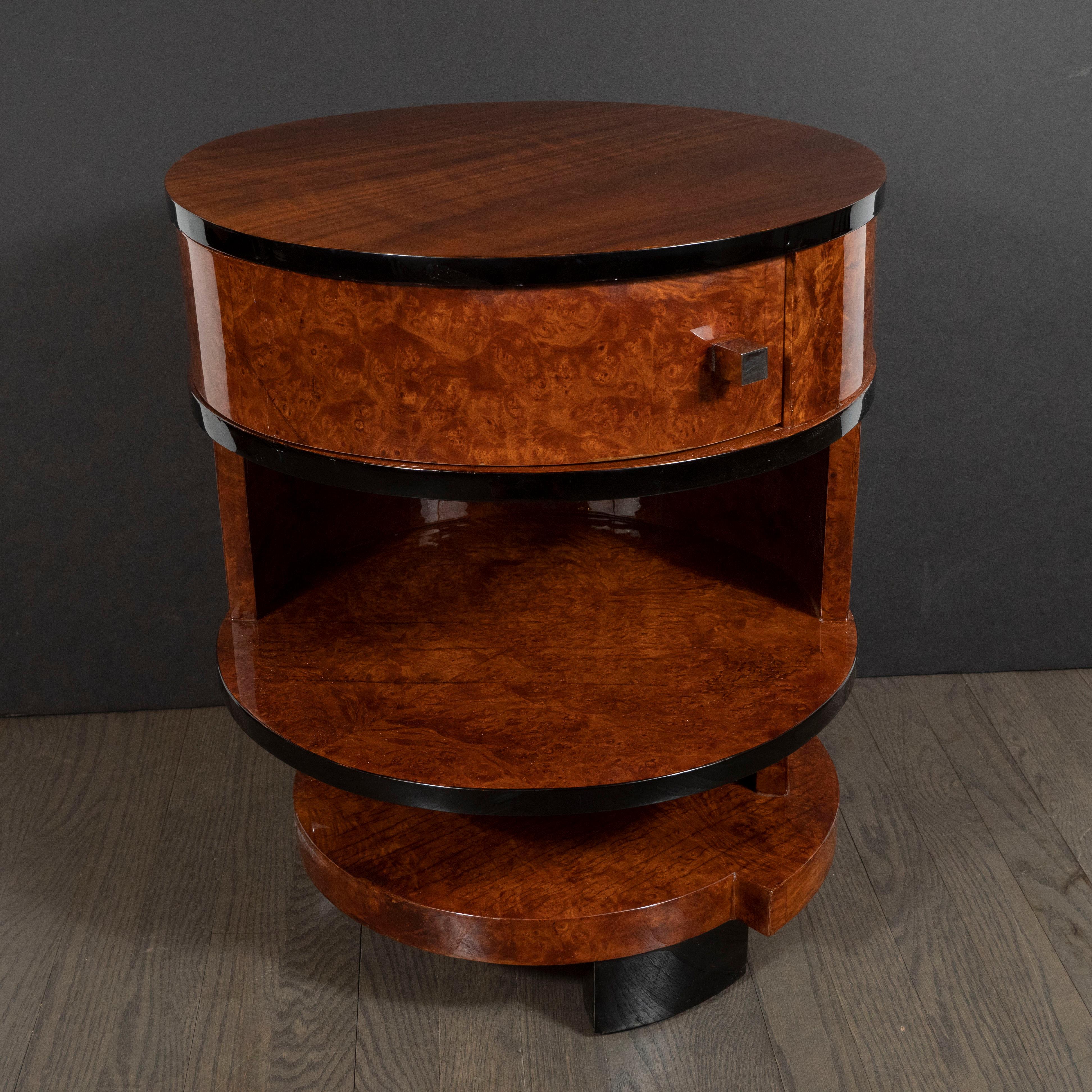 This elegant Art Deco Cubist side table was realized in France, circa 1935. It features a bookmatched walnut top circumscribed by black lacquer. There are two more black lacquer bands below, as well as two tiers offering a variety of storage