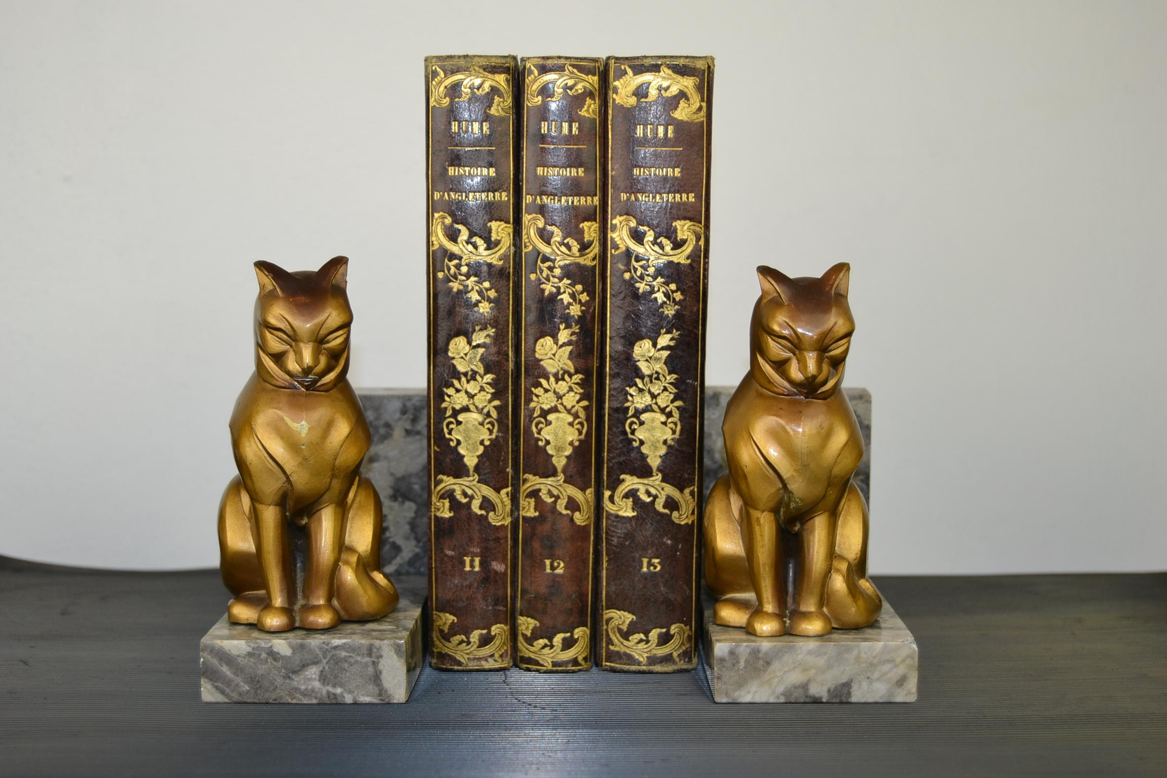Stylish Art Deco bookends with cats. These French cubist bookends are signed by Franjou and date 1930s .
The cats made of gold patinated metal, spelter are mounted on marble base. 

The bookends are in fair condition, they have traces of age and